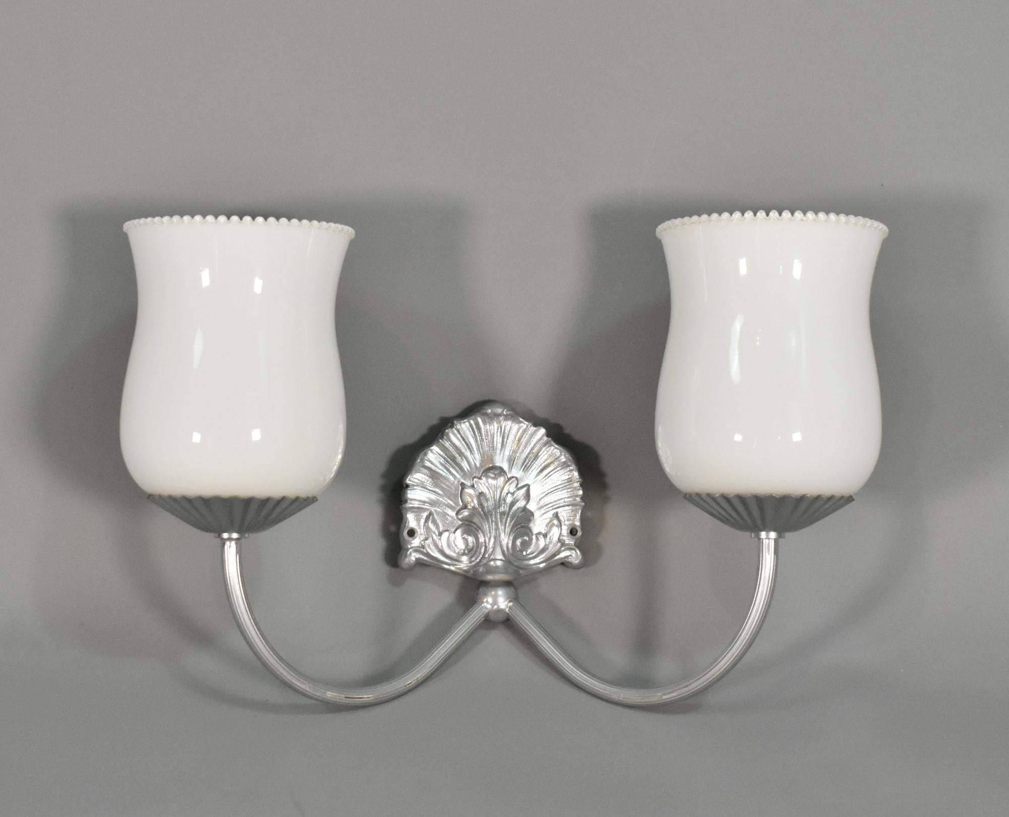 This vintage bathroom set of bathroom accessories comprises:
    • Three mirror plate holders (each measures height 8 cm; width 12 cm; depth 7 cm)
    • One double wall sconce with a pair of matching opaque glass shades that are tested and in
