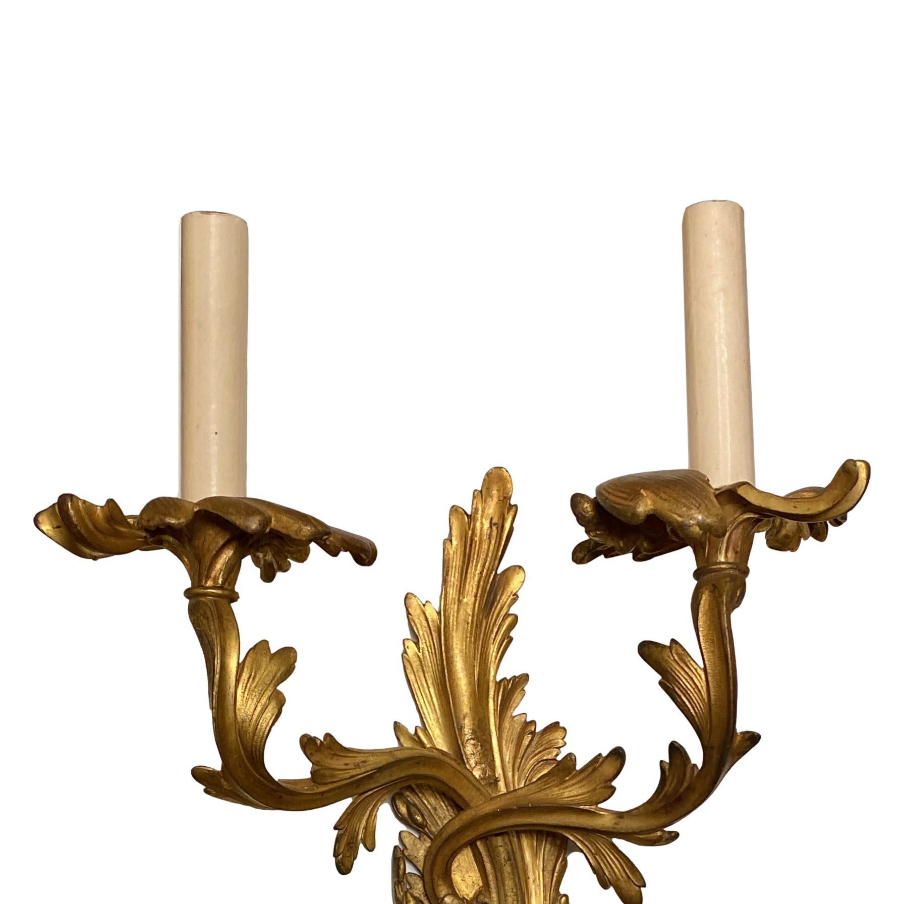 Ensemble de huit appliques à deux lumières de style Louis XV, datant des années 1920, en bronze doré, avec un motif de volutes sur le corps. Vendu par paire.

Mesures :
Hauteur : 22