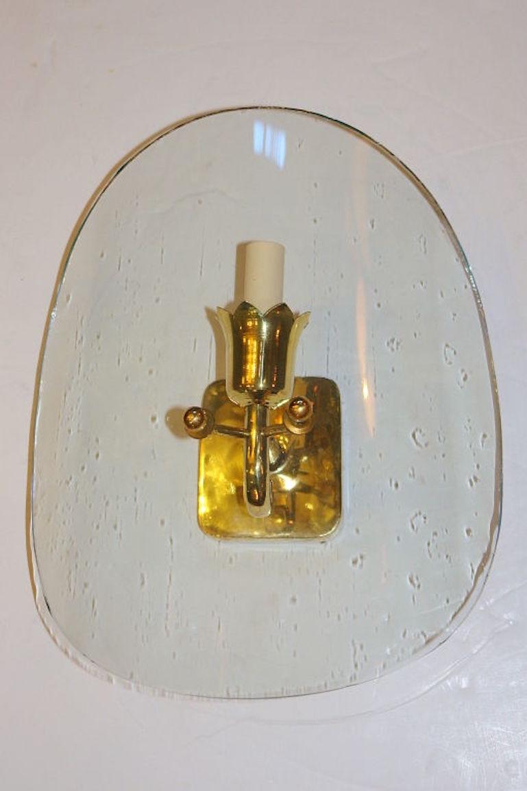 A set of four circa 1960's Italian gilt metal sconces with clear shield glass bent shades.
Sold per pair.

Measurements:
Height: 14