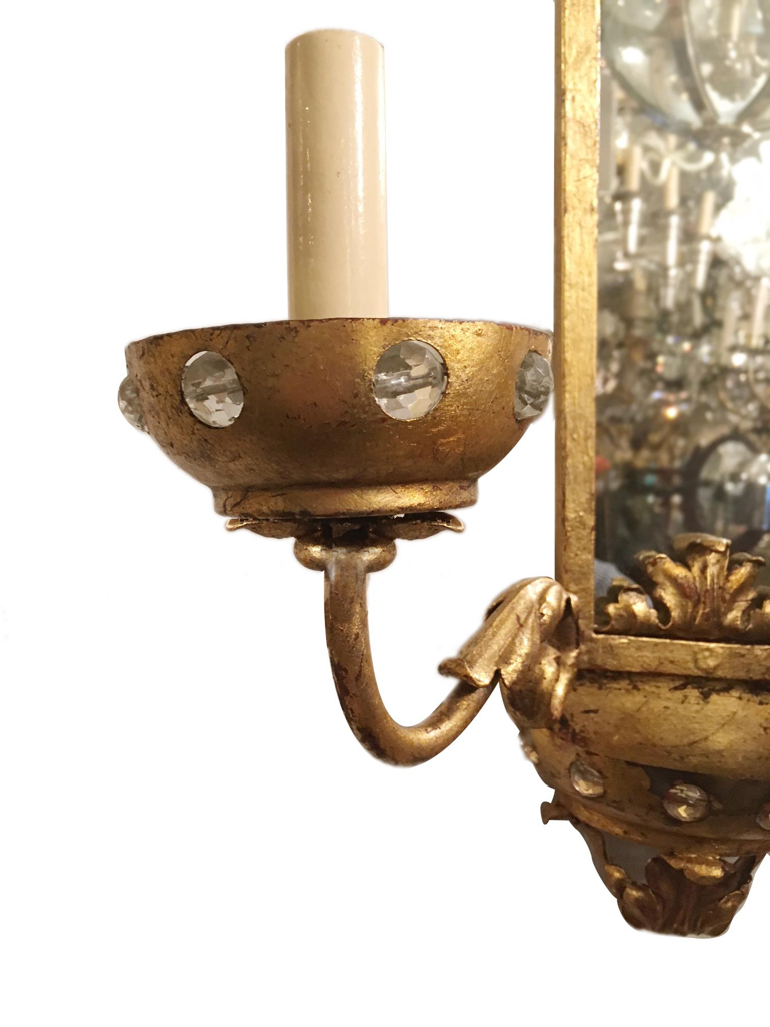 Set of four circa 1920's French gilt metal tw0-arm arms sconces with mirrored backplates and crystal-inset bobeches. Sold per pair.

Measurements
Height: 17