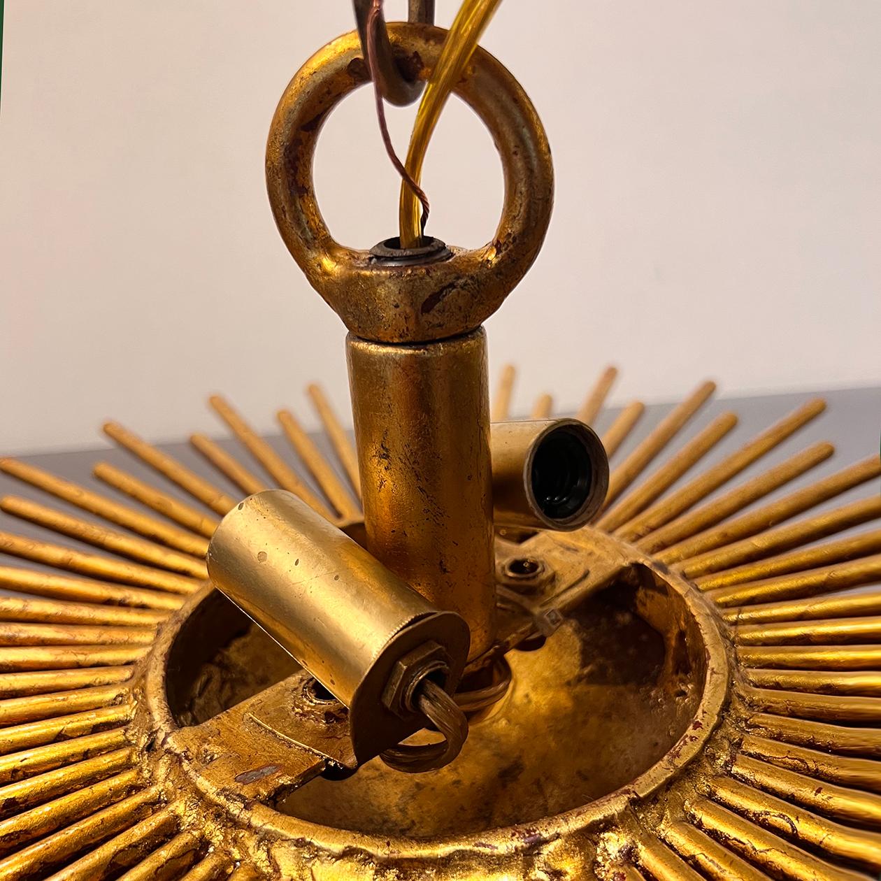 A set of circa 1930's French gilt metal light fixtures shaped as a sunburst, 2 interior candelabra lights each.  Sold individually.

Measurements:
Height (drop): 5