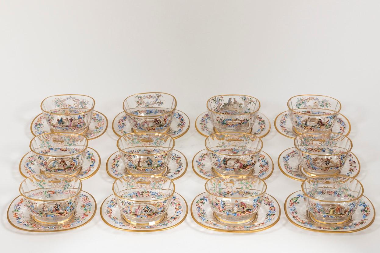 Set of twelve handblown glass bowls with under plates by Lobmeyer, circa 1890. Each bowl features an enamel depiction of a courting couple with floral garlands in cartouches and borders. Each piece signed Lobmeyer in Enamel.
 