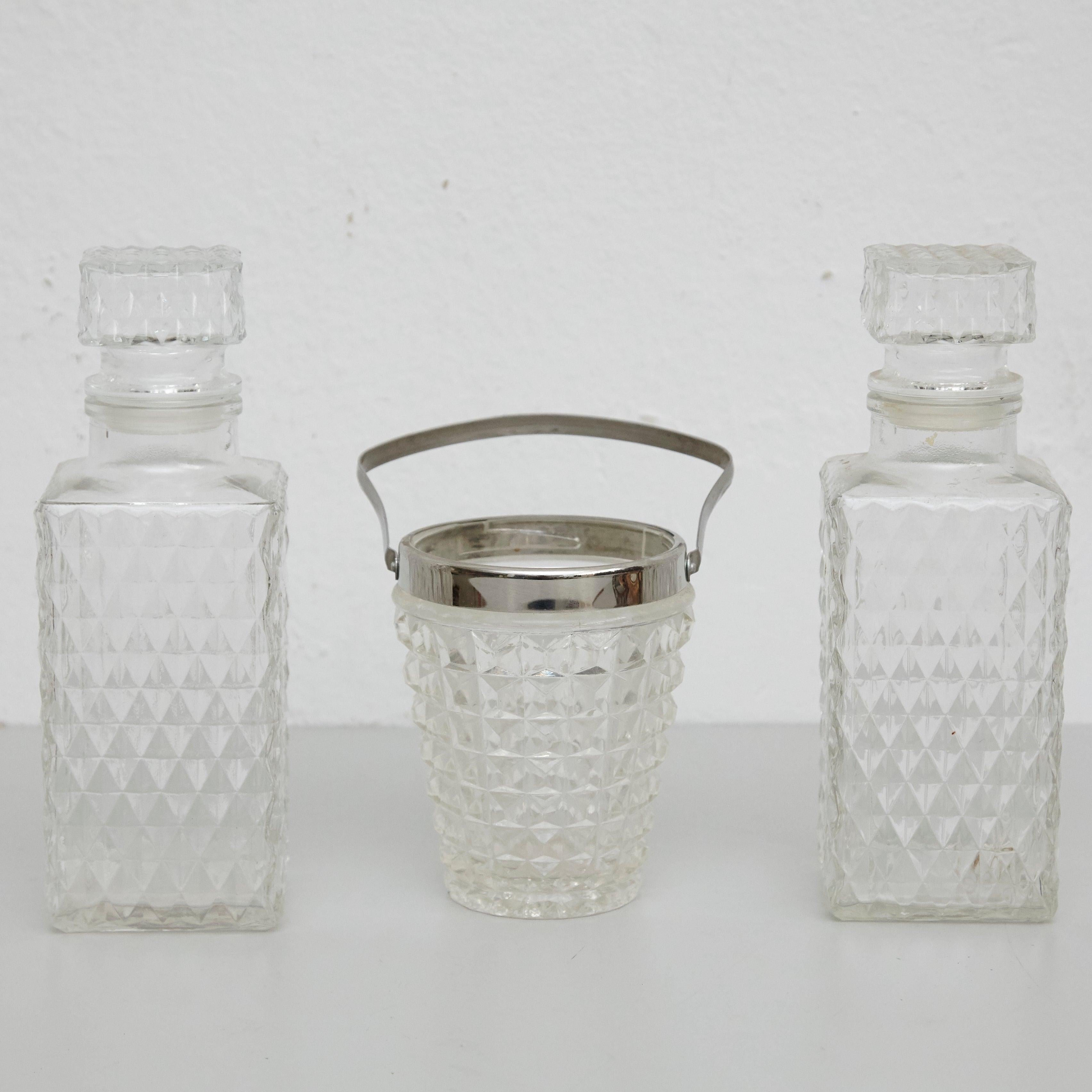 Set of Glass Whisky Bottles and ice bucket with faceted block crystal design. 
By unknown manufacturer, Spain, circa 1950.

In original condition, with minor wear consistent with age and use, preserving a beautiful
