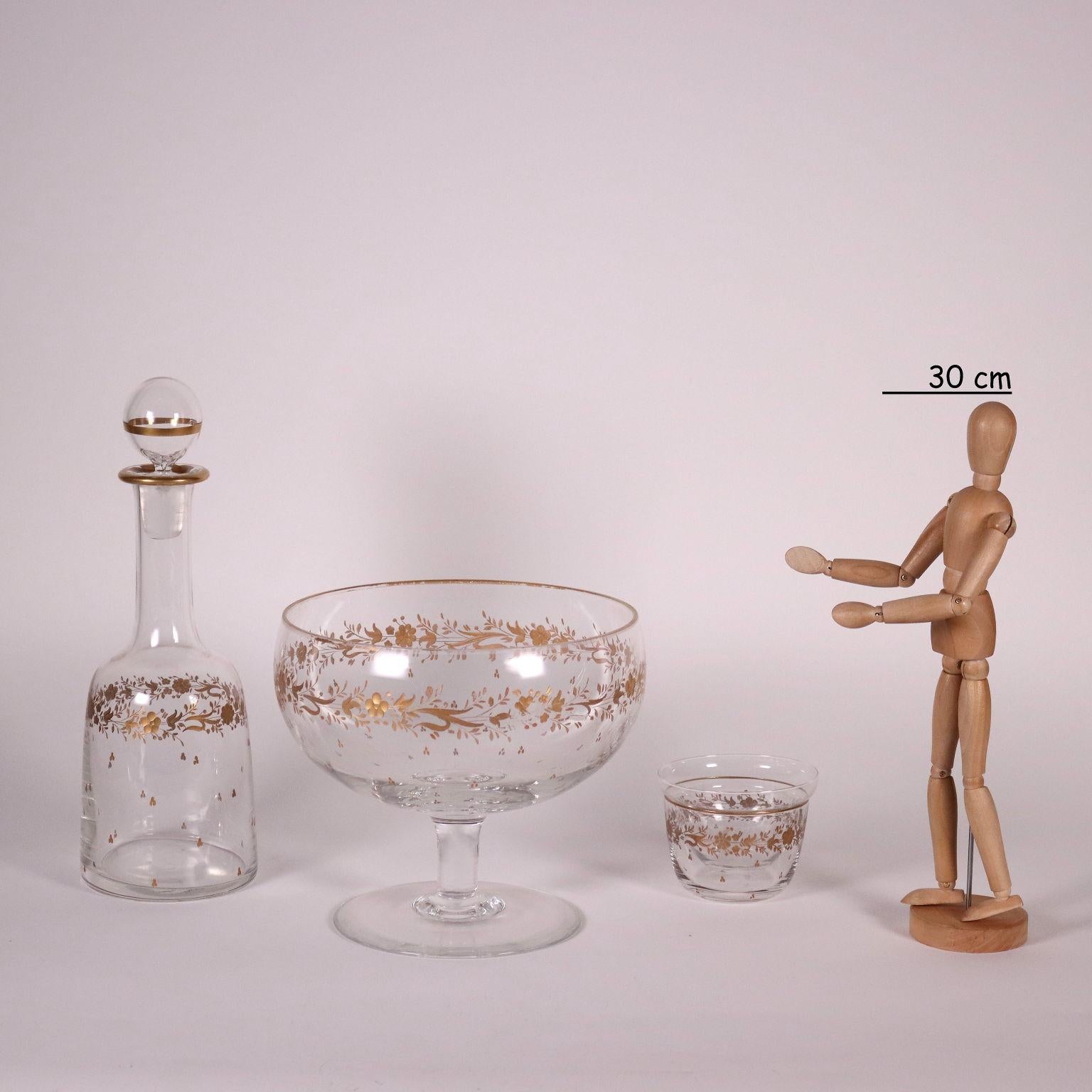 Set of glasses in cut crystal and highlighted in gold. The refinement of the decoration highlights the excellent quality of the manufacture. The set consists of: two bottles (one without cap), a jug, a bowl and two cup glasses, twelve half-moon