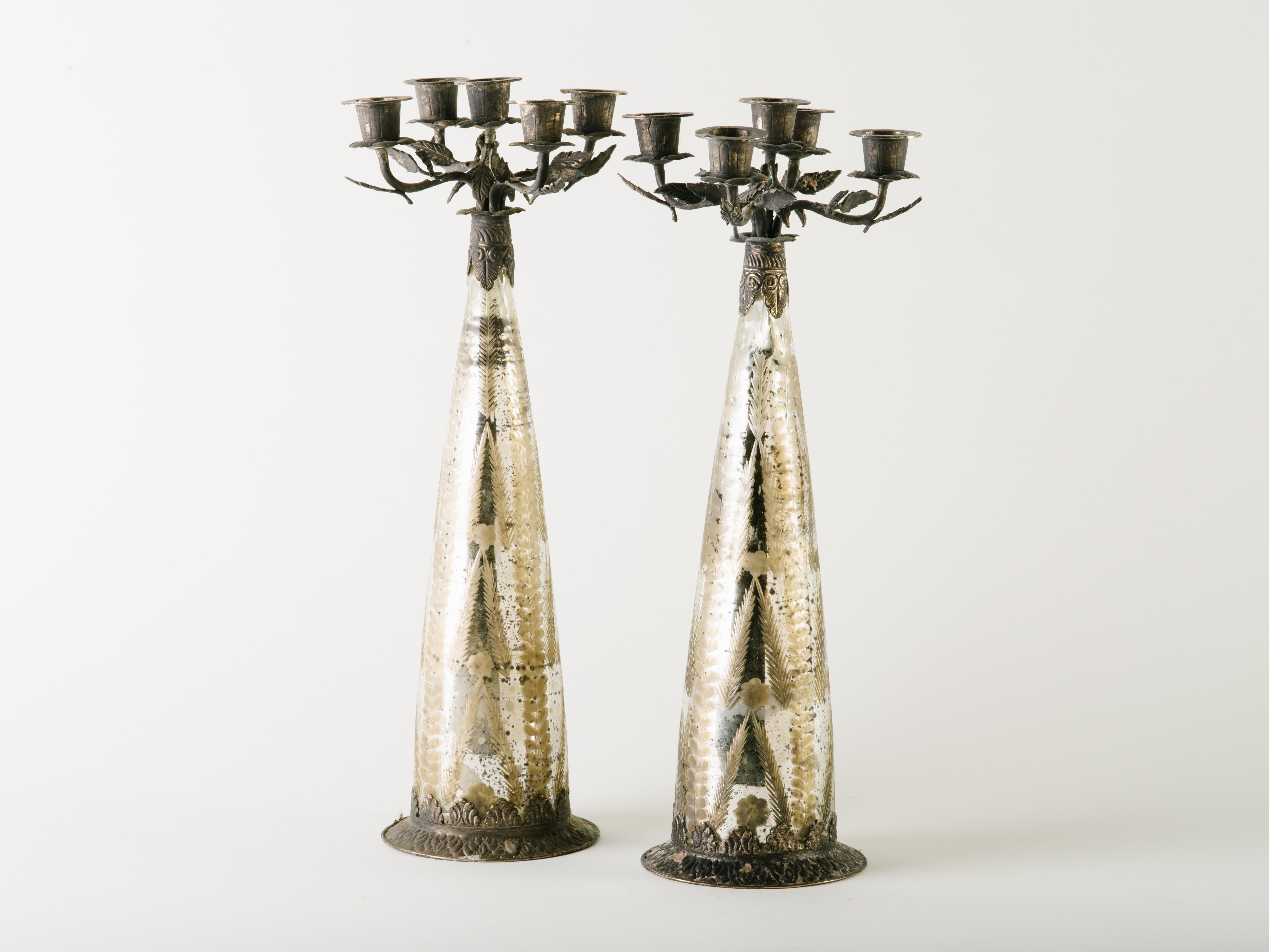 Stunning set of candelabra in antiqued mercury glass with etched designs. The candelabras have tapered forms with hand-forged metal designs throughout. Gothic Revival design features patinated metal leaves along the candle holders and along the