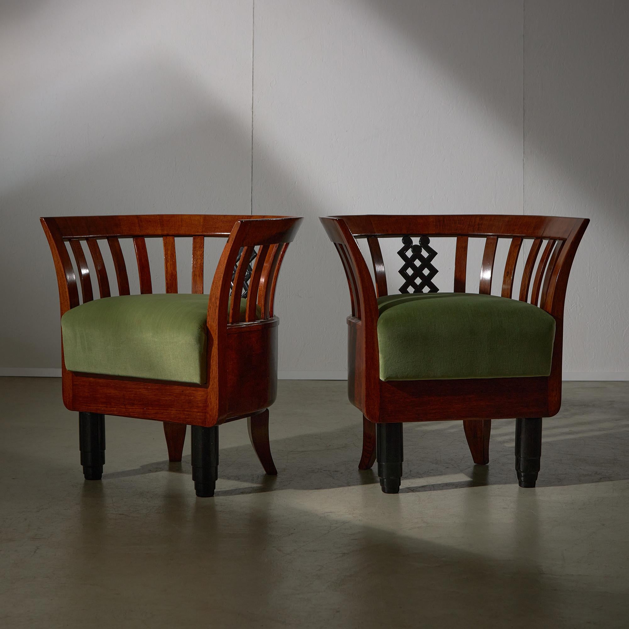 Questo impressionante  Il duo di poltrone Art Déco rivestite in velluto verde è completato da intricati accenti decorativi in legno. Realizzato in quercia segata a quarto di dollaro, favorita nella produzione di mobili per la sua stabilità e il suo