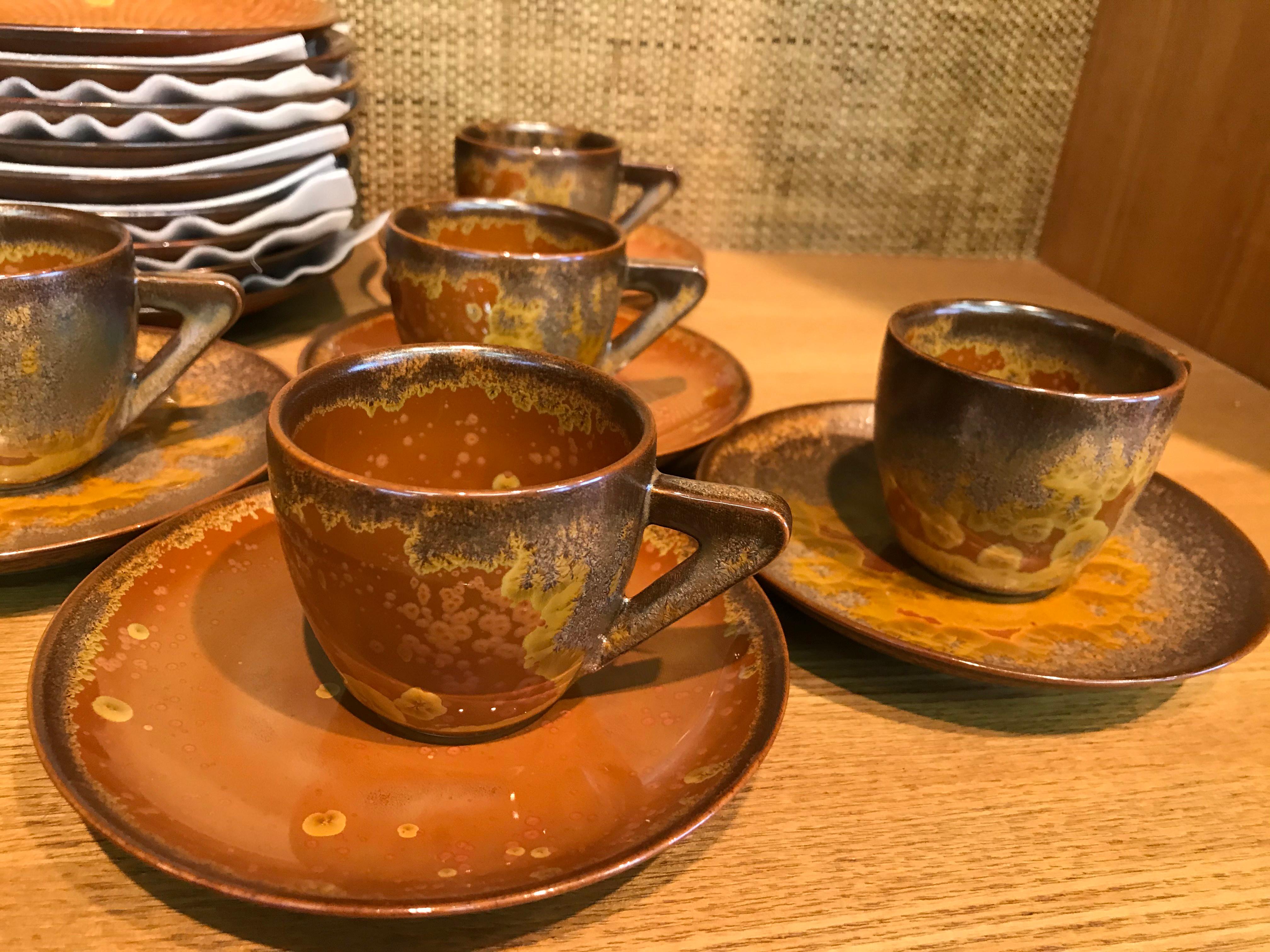 Unique set of nine Japanese contemporary porcelain espresso cups, saucers and dessert plates, hand-glazed in stunning signature golden brown color on a beautifully shaped body, signed pieces by highly acclaimed award-winning master porcelain artist