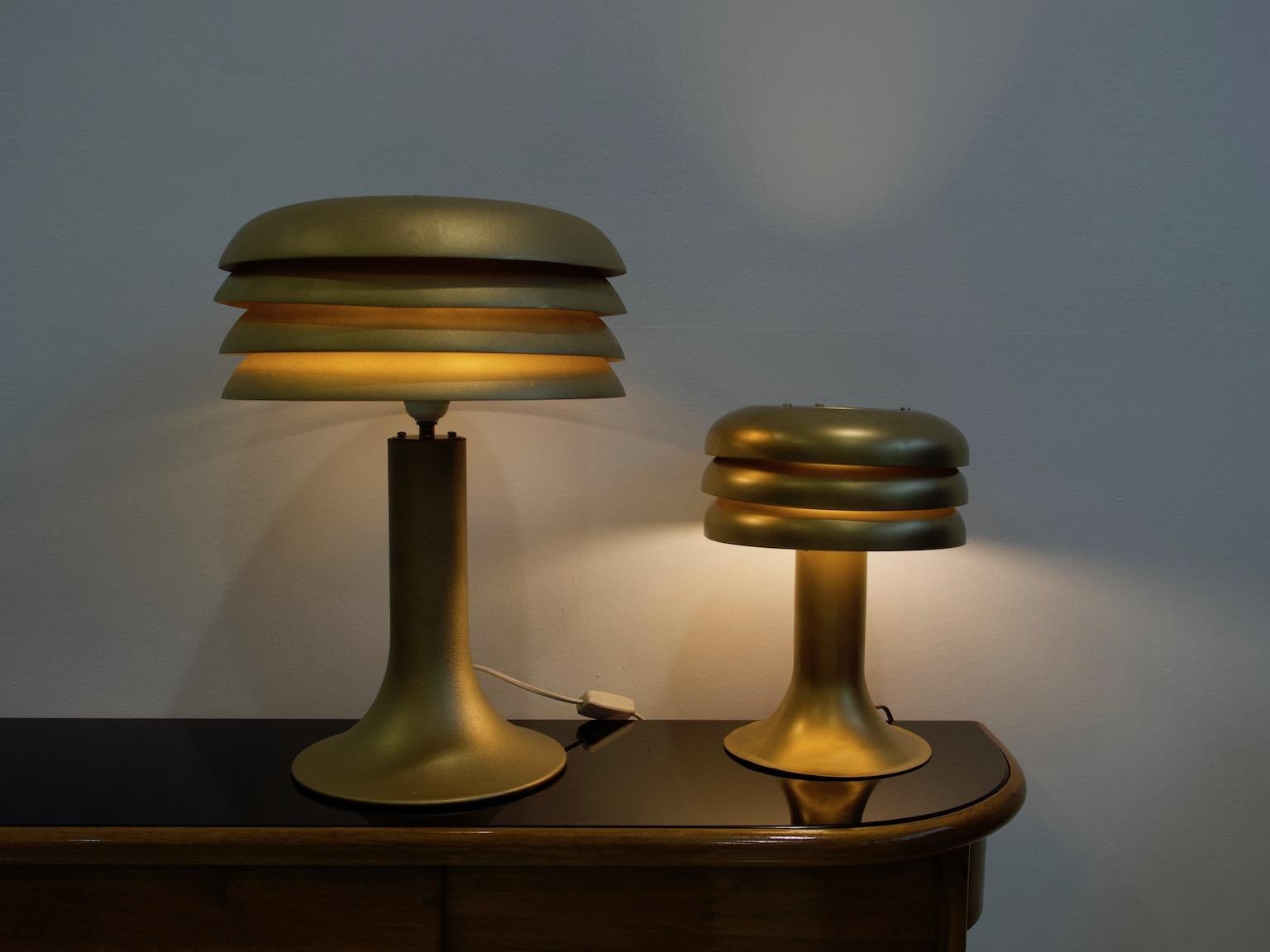 Two table lamps, models BN-25 and BN-26 of sheet metal designed by Hans-Agne Jakobsson. Height of smaller one is 31 cm and diameter 24 cm. Height of the taller lamp 48 cm and diameter 33 cm. Some age-related wear, re-lacquered.