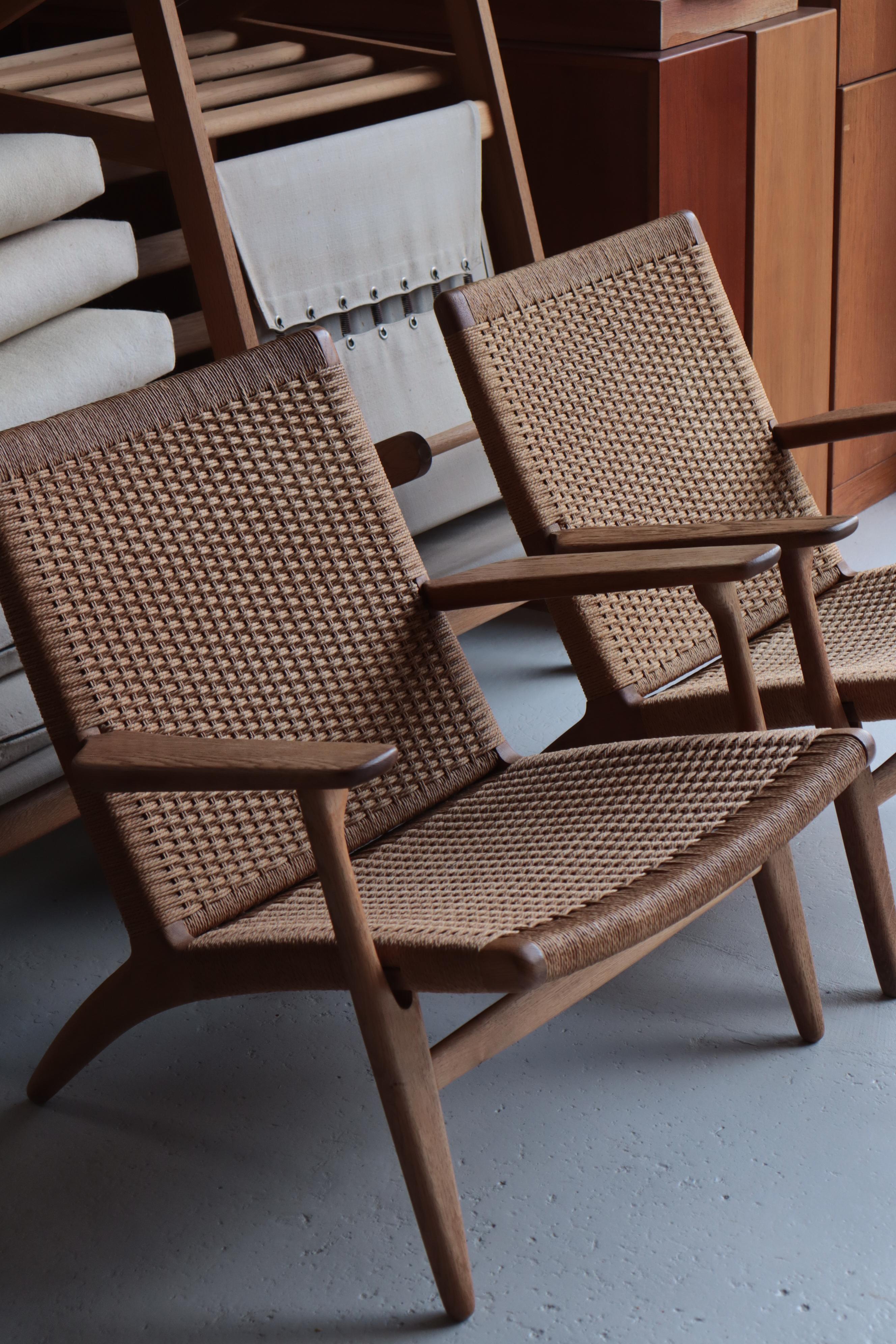 Paire de chaises longues Hans J. Wegner modèle CH25 fabriquées dans les années 1960 par Carl Hansen & Son. Chêne et corde à papier. Bon état avec le tissage original de la corde en papier.