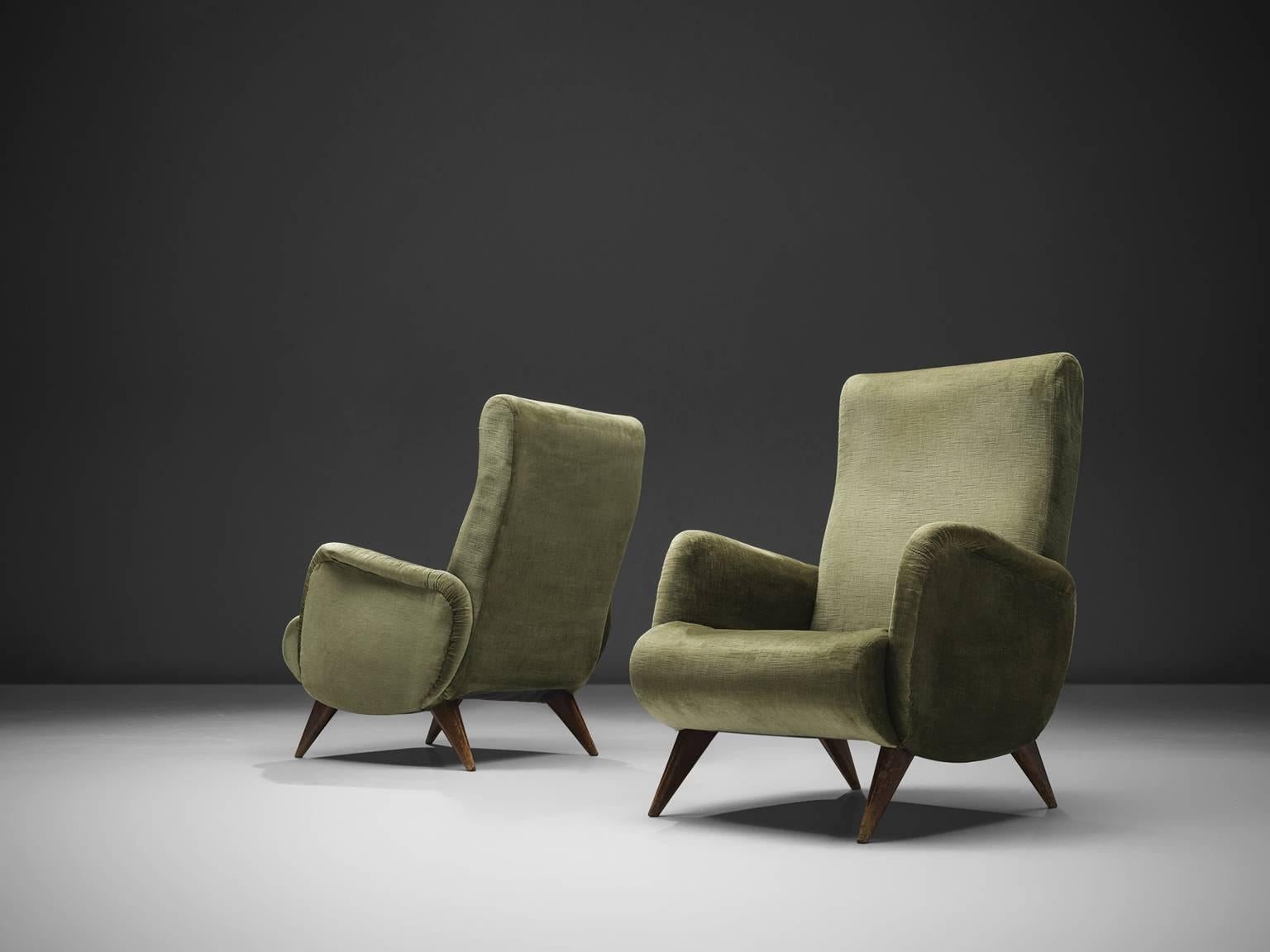 Easy chairs, green velvet, wood, Italy, 1950s

These easy chairs has thick armrests, full and rounded on the top. The sides are smooth and soft and the armrests rise slightly upwards. The feet are short and cylindrical and tapered towards the