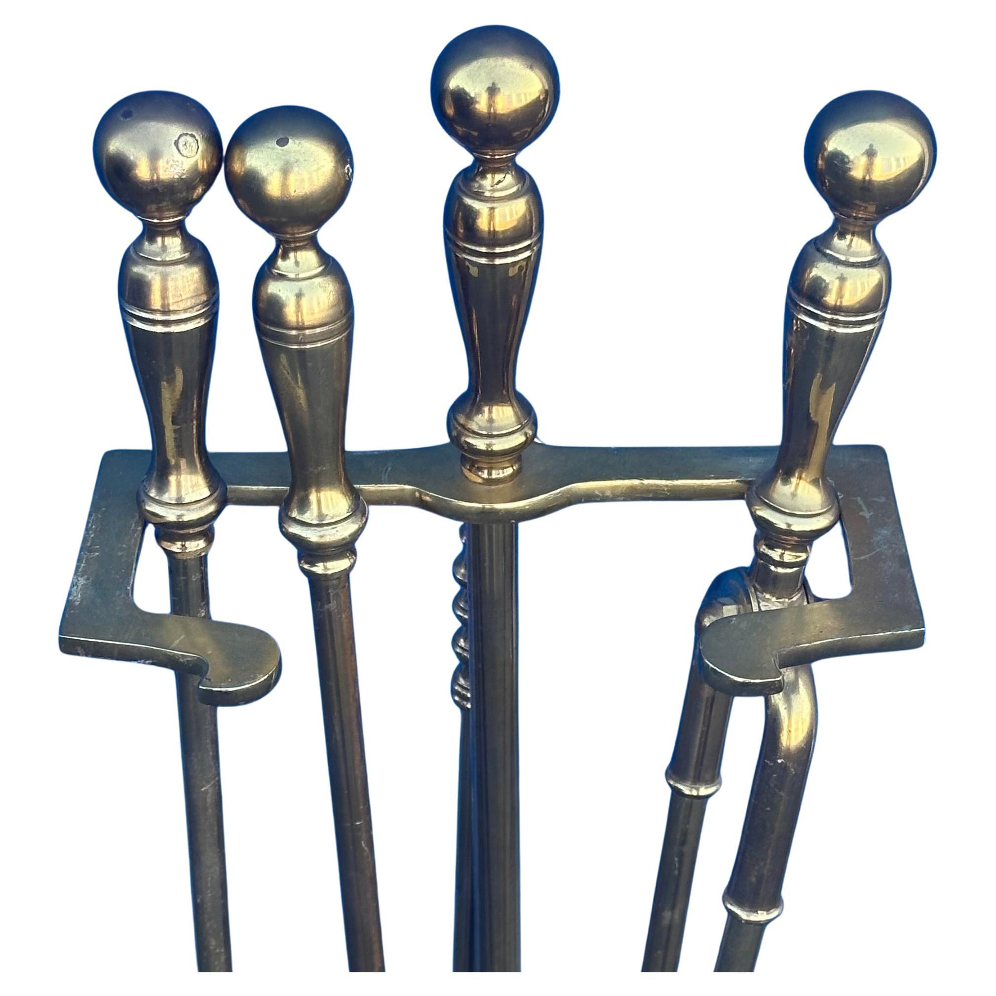 Elegant set of Hollywood Regency brass fireplace tools, circa 1970s. Amazing quality; very heavy with nice detail on the handles. Set includes a shovel, brush, poker and log holder. #3802