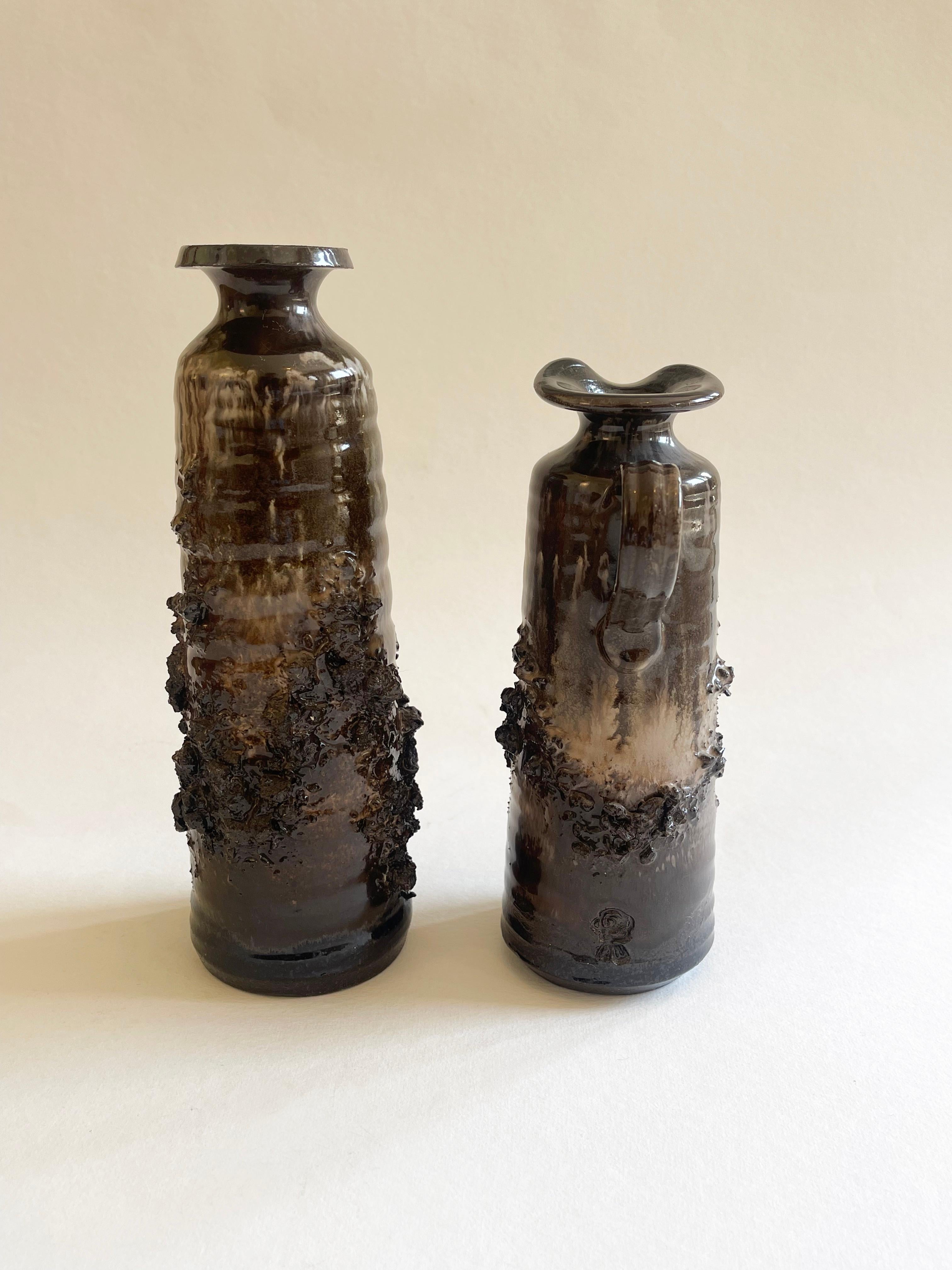 Mid-century set of 2 beautiful Scandinavian ceramic vessels by Ragnar Kjartansson (1923-1989) of Iceland. 
Ragnar Kjartansson a sculptor and ceramist helped founding Glit Pottery in 1958. 
Rocky hardened lava ceramic in brown and beige tones.
The