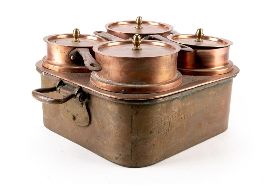 Set of antique early 20th century Lewis Conger [New York/France] copper pots in a large portable boiler. Includes four fitted pots with lids each bearing the manufacturer's mark and iron handles. Each paced in a fitted circular slot inside of a