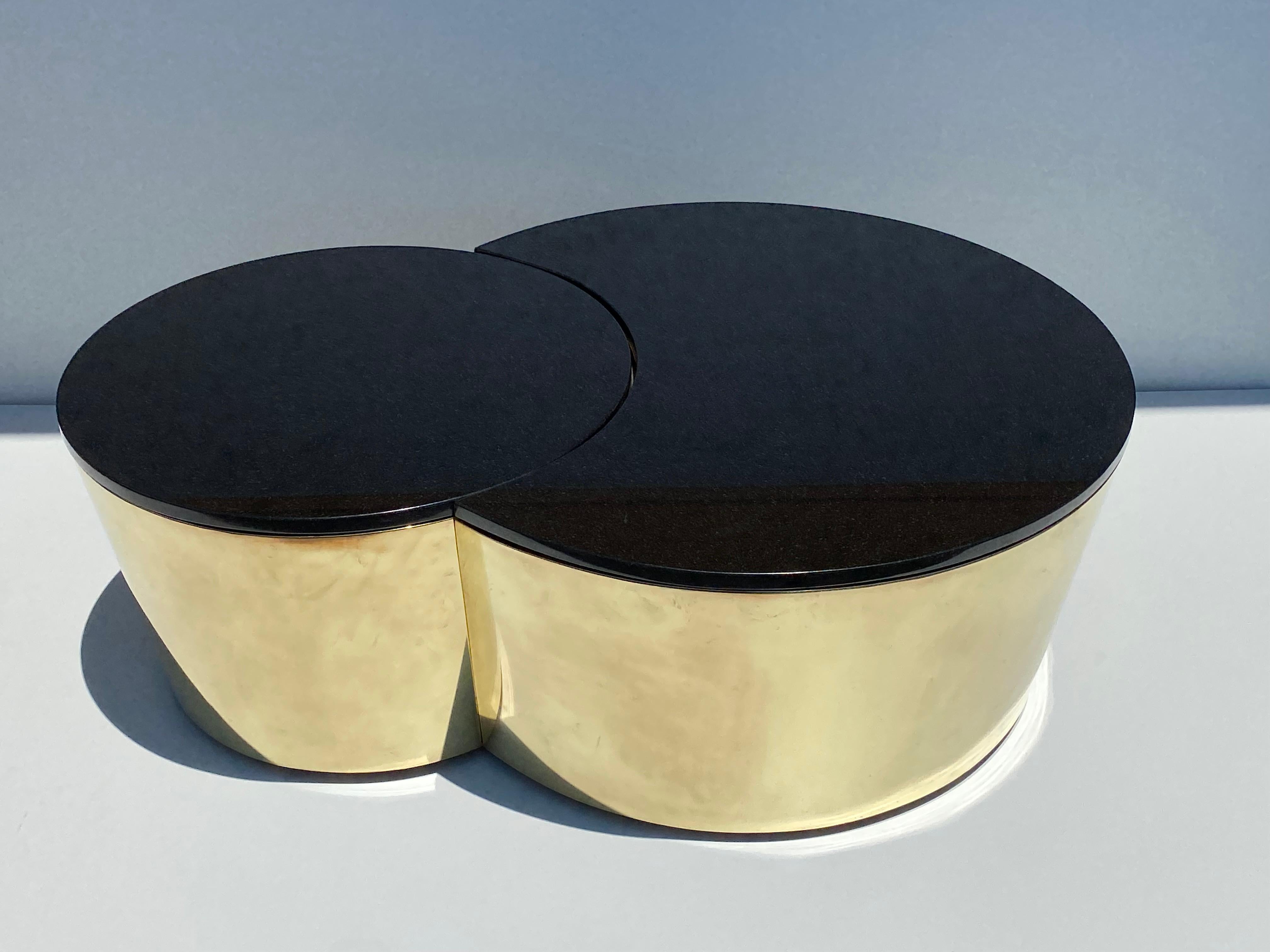 Set of interlocking brass and black granite coffee tables in the style of Karl Springer. Larger table is 27