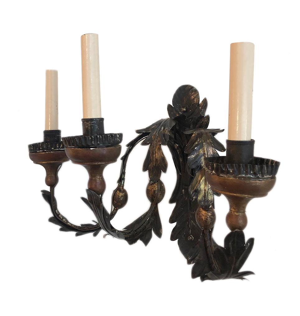 Set of four circa 1920's Italian three-arm iron and tole sconces with giltwood elements and painted finish on body and backplate.

Measurements:
Height: 12.5