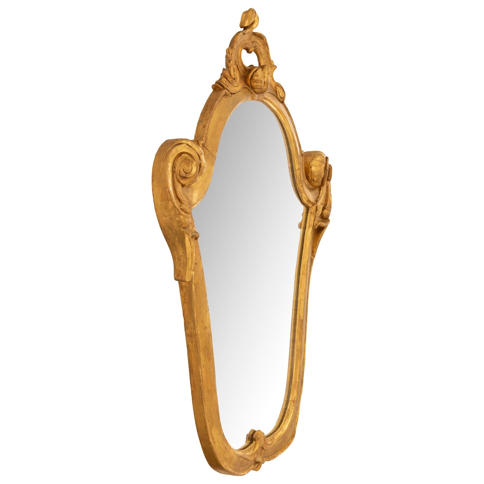 An elegant and very unique set of six Italian 19th century giltwood Venetian mirrors. Each lovely mirror with a scrolled oval shaped frame has an acanthus leaf at the bottom with lovely scrolled sides. At the top is a pierced scrolled design with