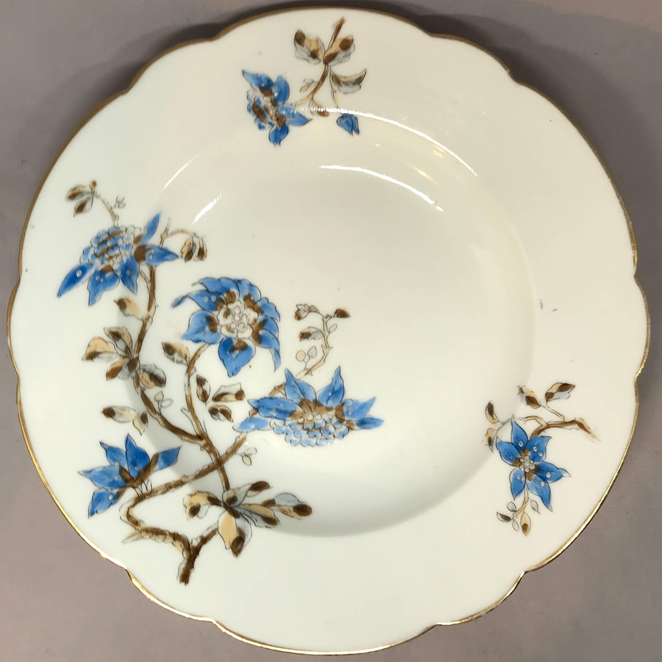 Ensemble de cinq assiettes italiennes à décor floral bleu et blanc. Cinq assiettes creuses lobées et dorées à décor floral bleu et brun, Italie, vers 1890. 
Dimensions : 9,88
