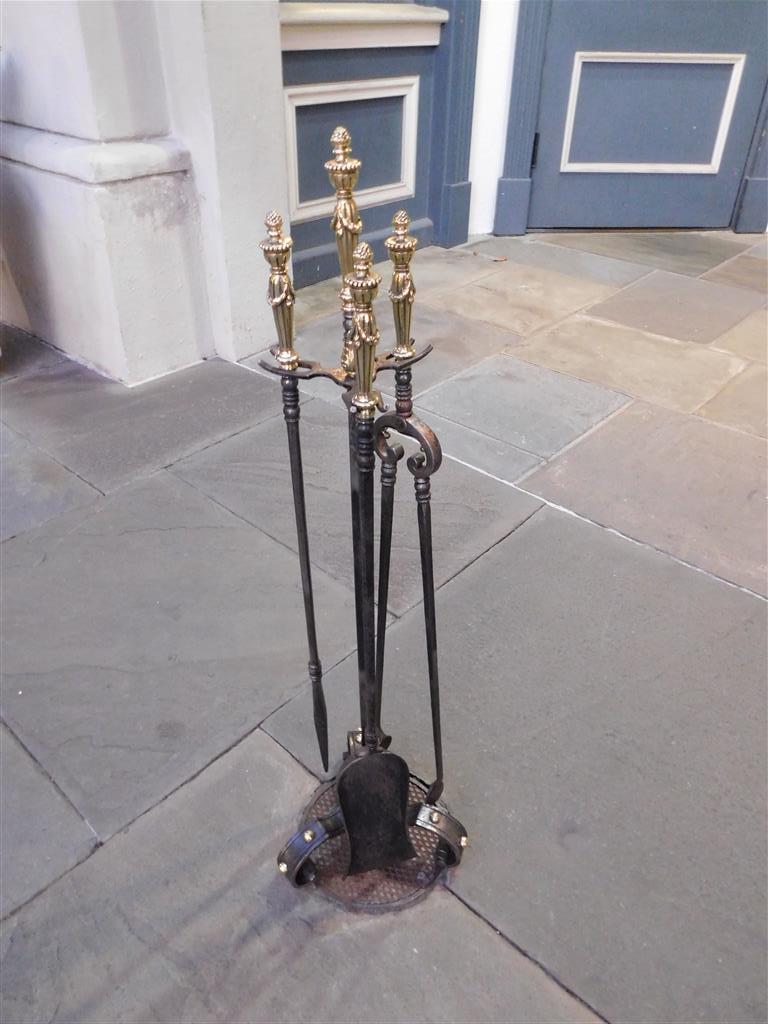 Set of Italian decorative brass and wrought iron fireplace tools on stand with fluted urn finials and swags, and resting on three incised medallion scrolled feet. Early 19th century. Set consist of tong, poker, and shovel.