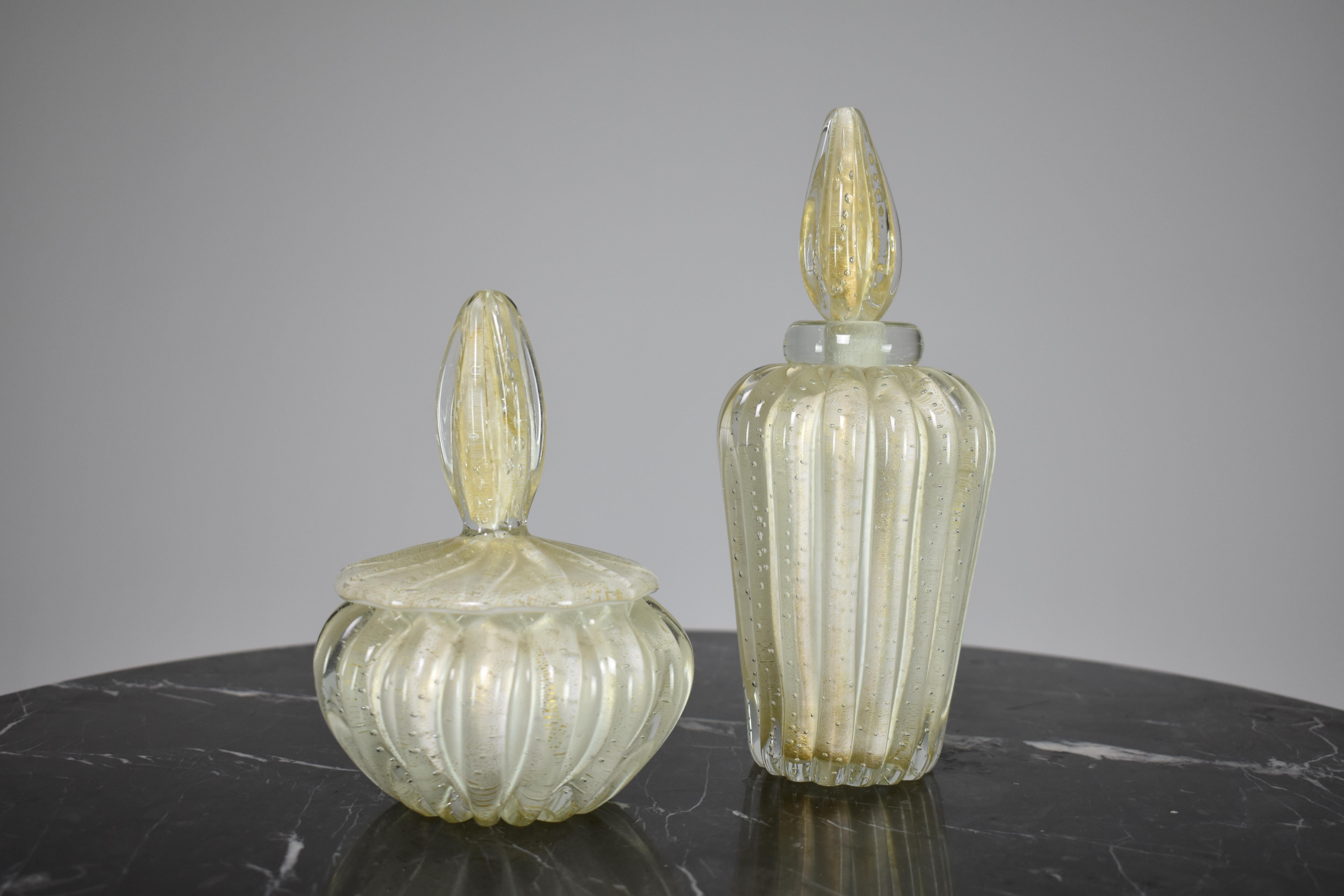 
Ein Set aus zwei Karaffen für Parfüm und Puder, mundgeblasen aus italienischem Murano-Glas und entworfen von dem bedeutenden Alfredo Barbini. Dieses exquisite Sammlerstück ist weiß mit Blasenglaseffekten und goldenen Sprenkeln. Es ist eine