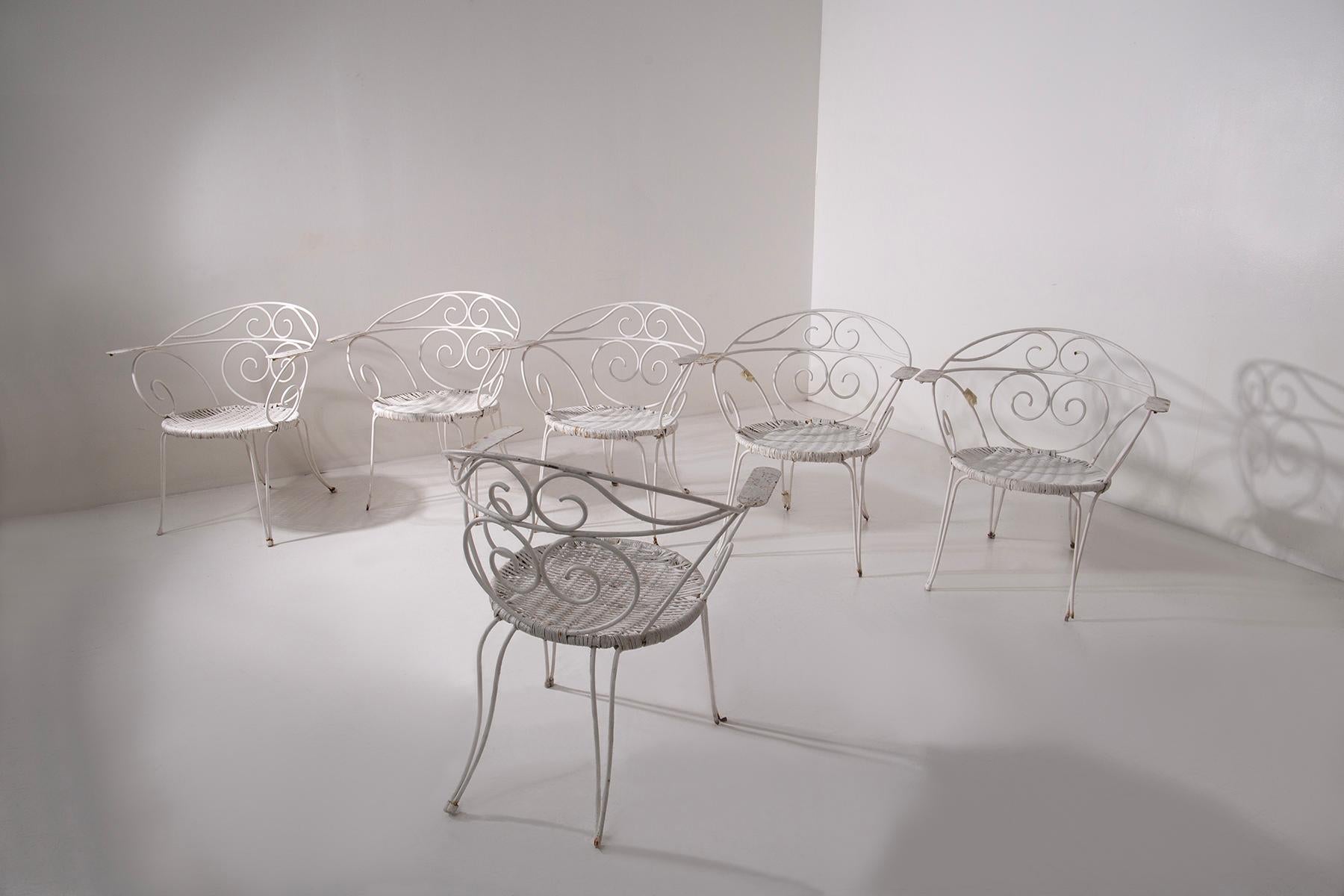 This refined set of six Italian garden chairs from the 1950s is an authentic example of period design designed for outdoor living with elegance and style. Made of curved painted iron, the chairs are distinguished by their sinuous shapes, rich with
