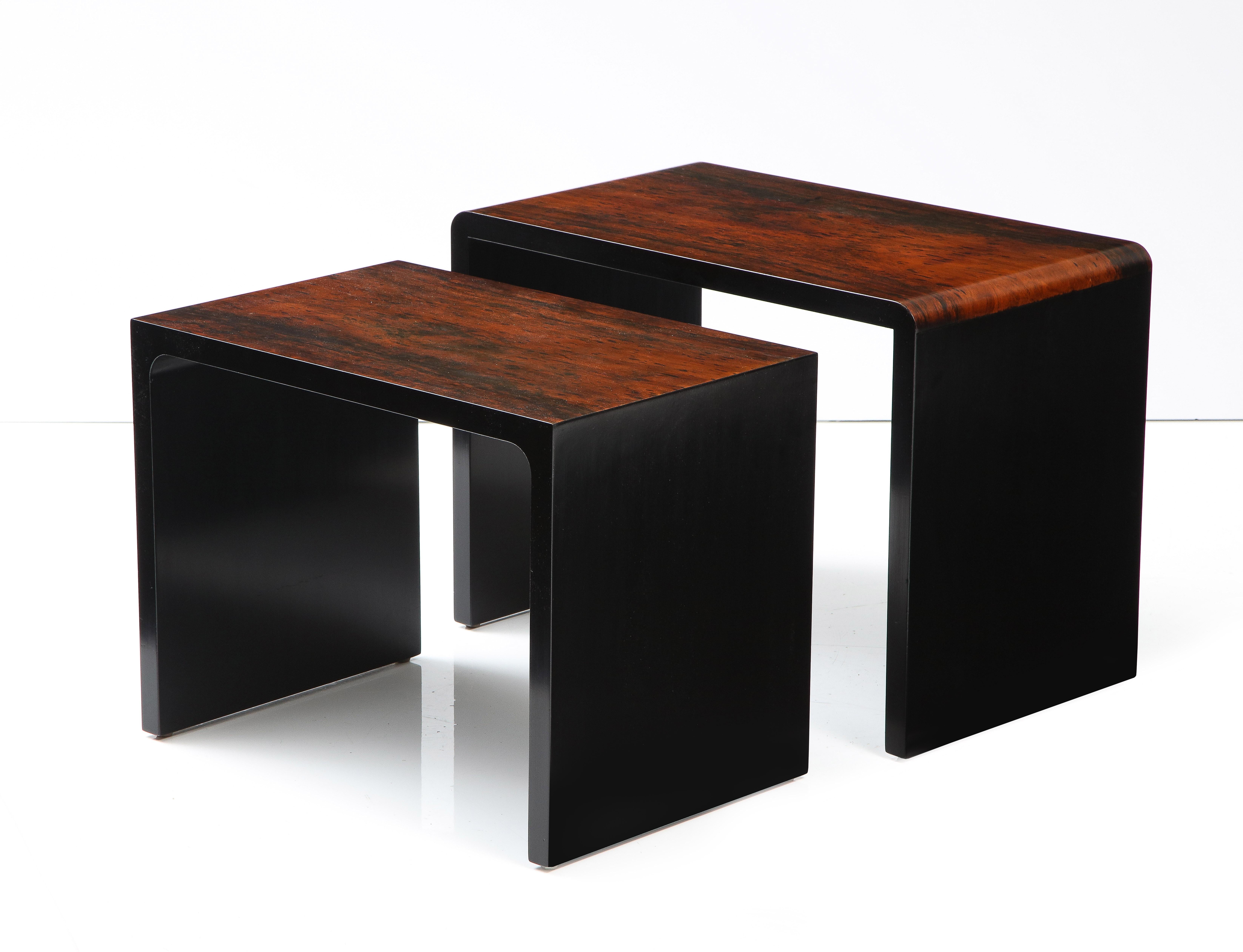 Set of two lacquered rosewood and ebony waterfall nesting tables. Highly polished and glamourous these pieces are indicative of the Italian chic of the 1970's. The contrast of the two woods is stunning, the craftsmanship superb. 
Italy, circa 1970