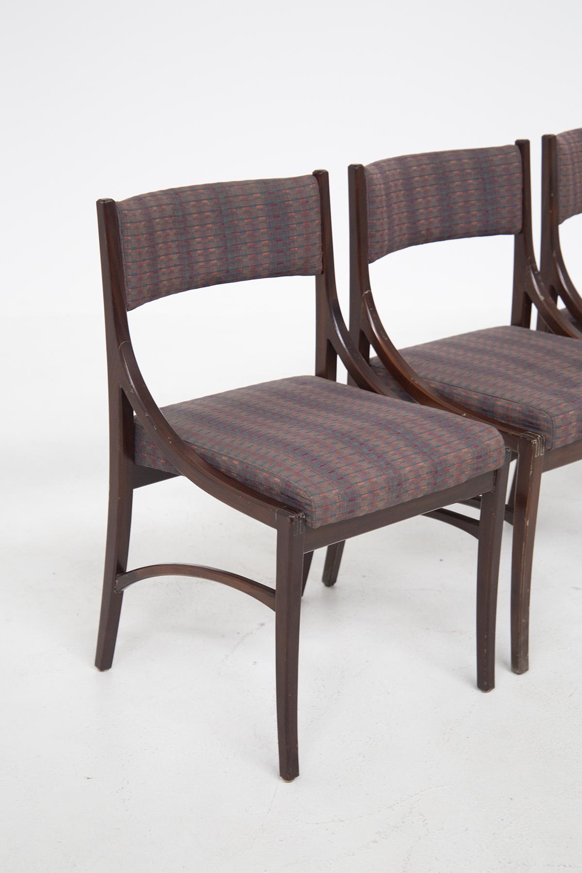 Set bestehend aus vier italienischen Vintage-Stühlen aus den 1970er Jahren. Die Stühle haben einen Rahmen aus dunklem Holz und umrahmen die Sitzfläche mit geschwungenen und weichen Formen. Die Sitzfläche und die Rückenlehne der italienischen