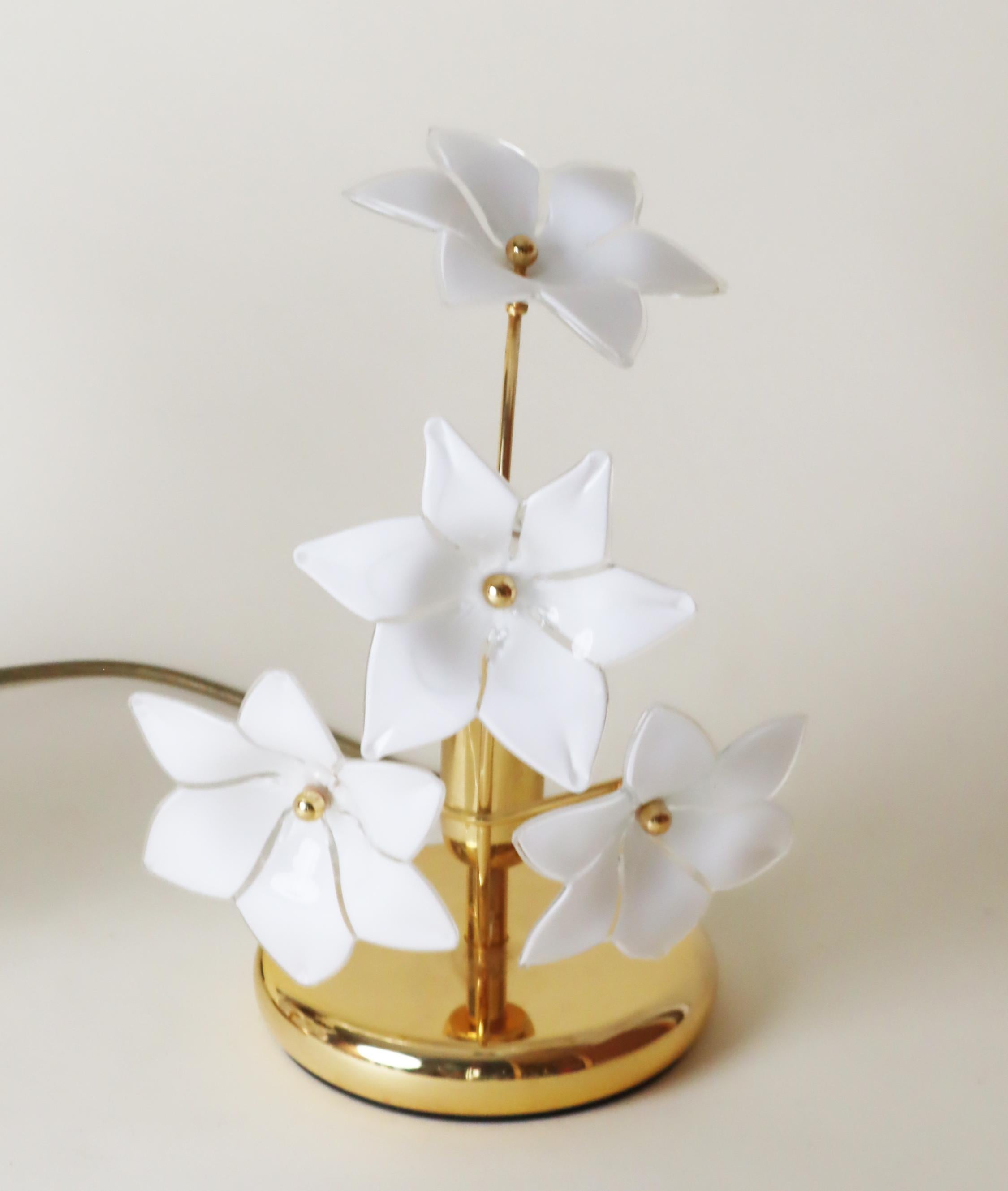 Cet ensemble de deux lampes de table délicates a été fabriqué en Italie. Les fleurs en verre blanc sont conçues avec art et montées individuellement sur le cadre doré de la lampe. La lumière est si enchanteresse, avec les belles fleurs et l'or qui