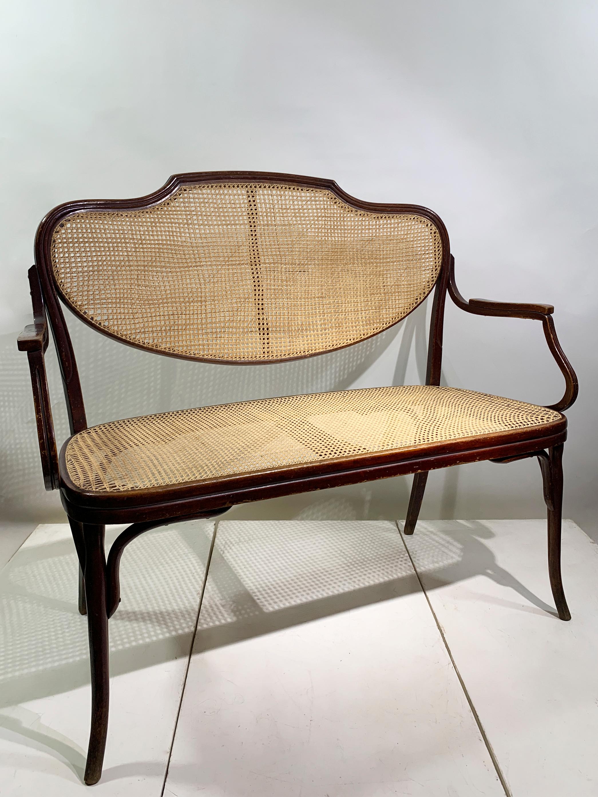 An elegant and authentic bentwood bench/sofa by the celebrated Austrian manufacturer J. & J. Kohn, dating to the turn of the 20th century. This exceptional piece exemplifies the artistry and innovation of the bentwood furniture movement, which