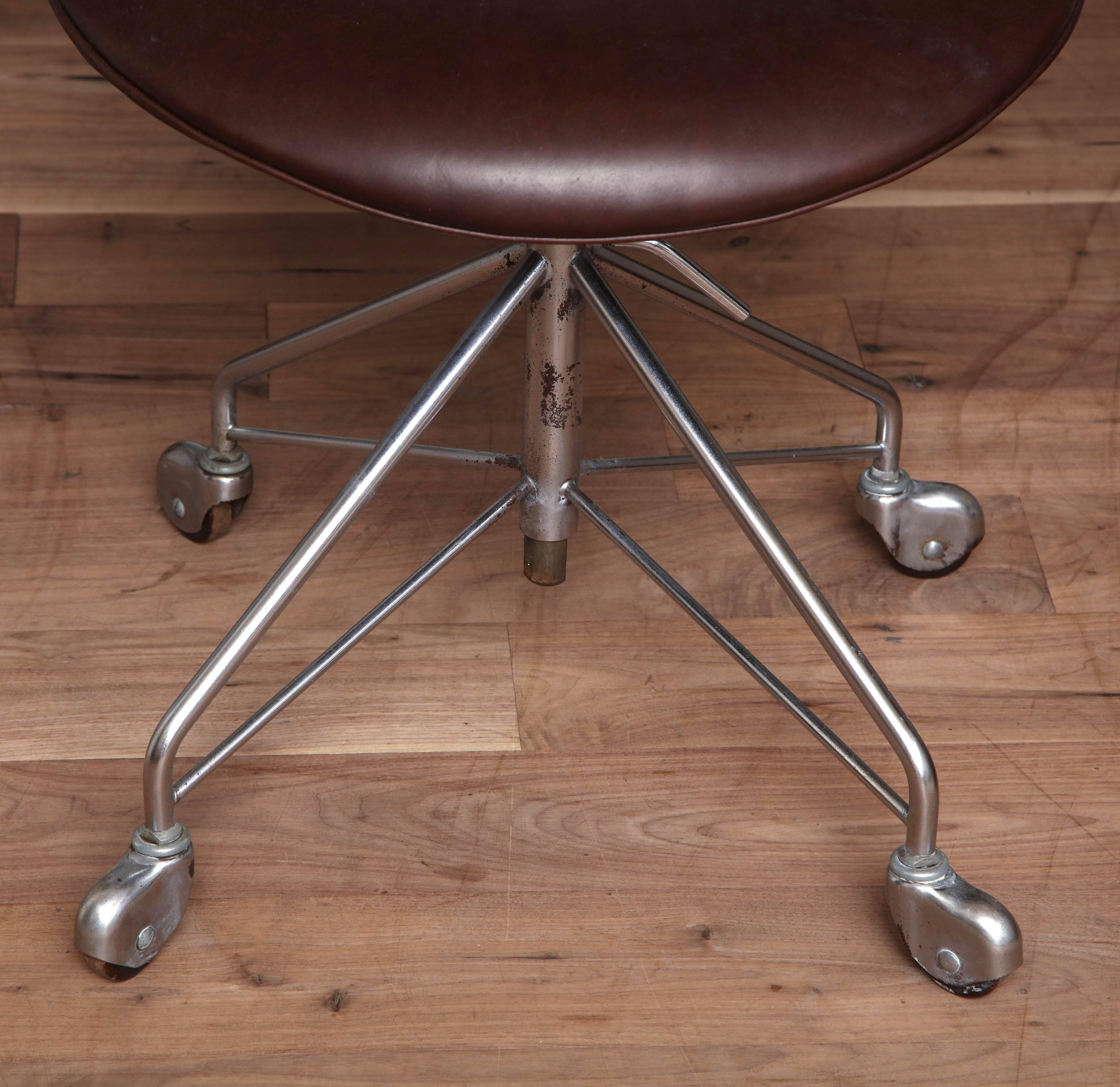 Set of four Arne Jacobsen series seven chairs with armrests, model 3217, Denmark, circa 1955 with original Fritz Hansen labels; this is an early set with four-star, chromed steel caster bases, and height adjustable swivel seats, reupholstered in