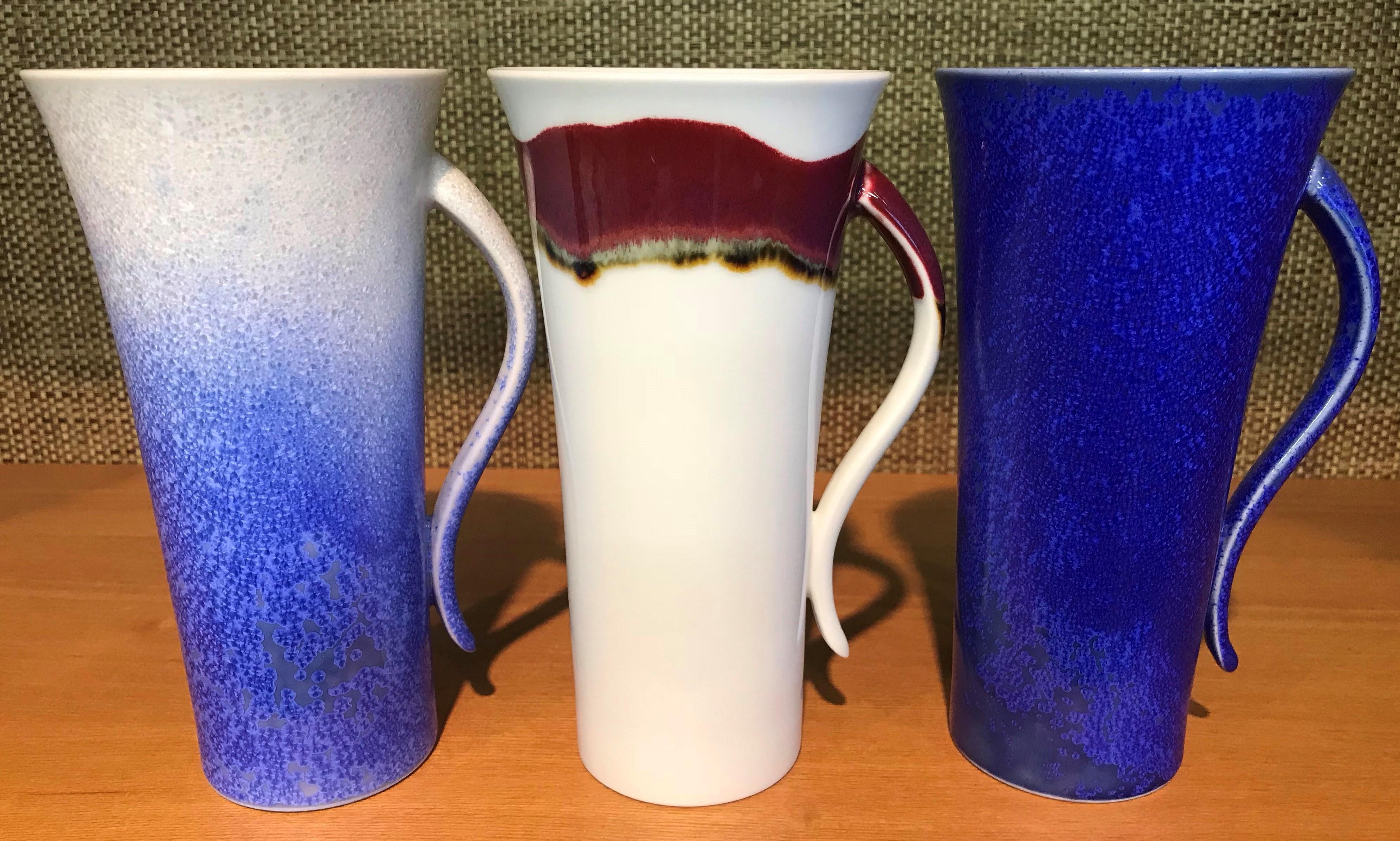Set of three unique contemporary tall Japanese hand-glazed porcelain mug cups in a beautiful shape artistically glazed in wine-red, blue and white, signed pieces by widely respected award-winning master porcelain artist in 