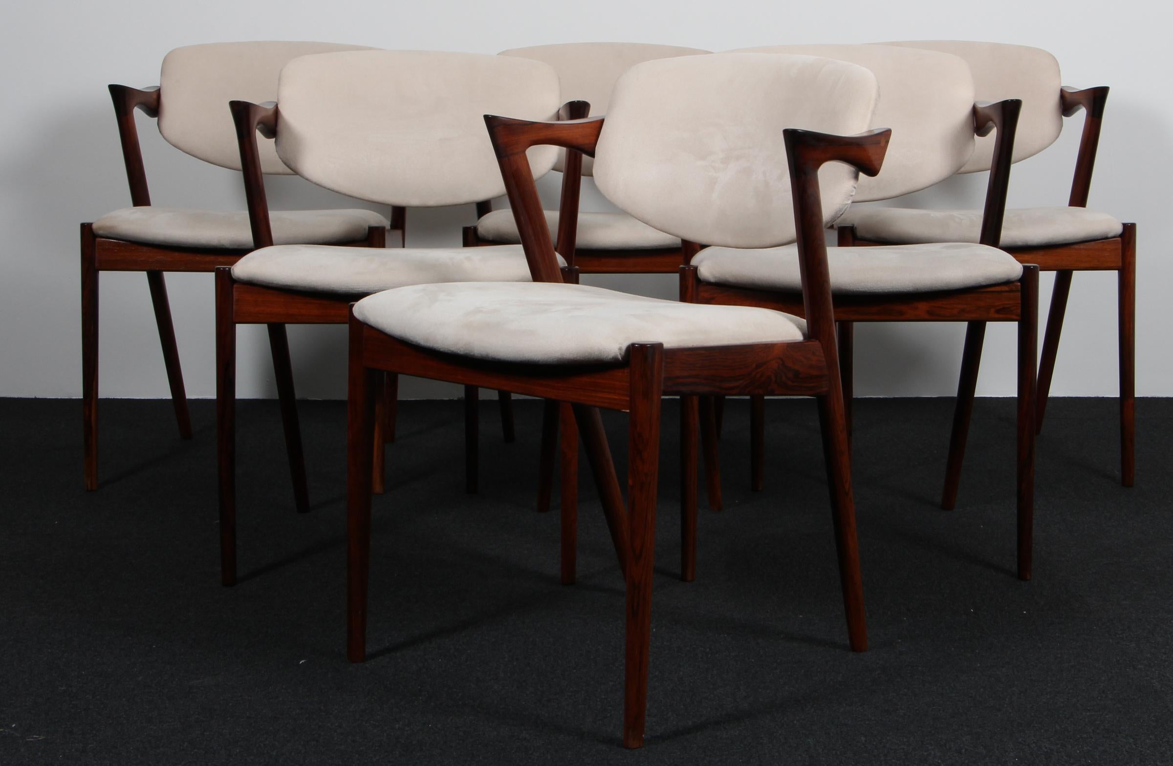 Set of dining chairs produced by Skovman Andersen for the Illum Bolighus department store in Copenhagen. Rosewood frames with seat and back upholstered with white alcantara. Back pad has tilt function for added comfort.
 