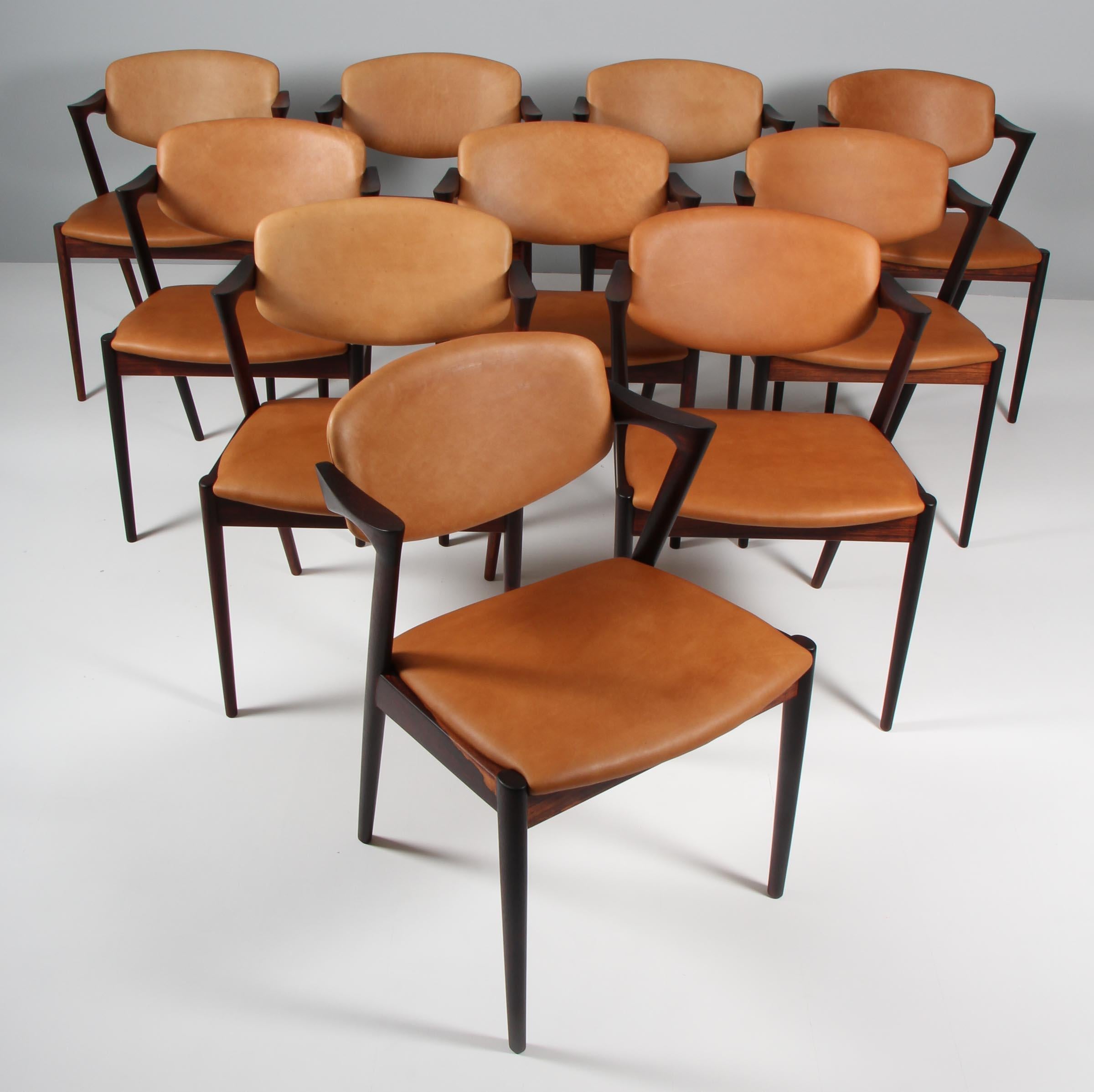 Set of dining chairs produced by Skovman Andersen for the Illum Bolighus department store in Copenhagen. Rosewood frames with seat and back reupholstered with vintage tan aniline leather. Back pad has tilt function for added comfort.
 