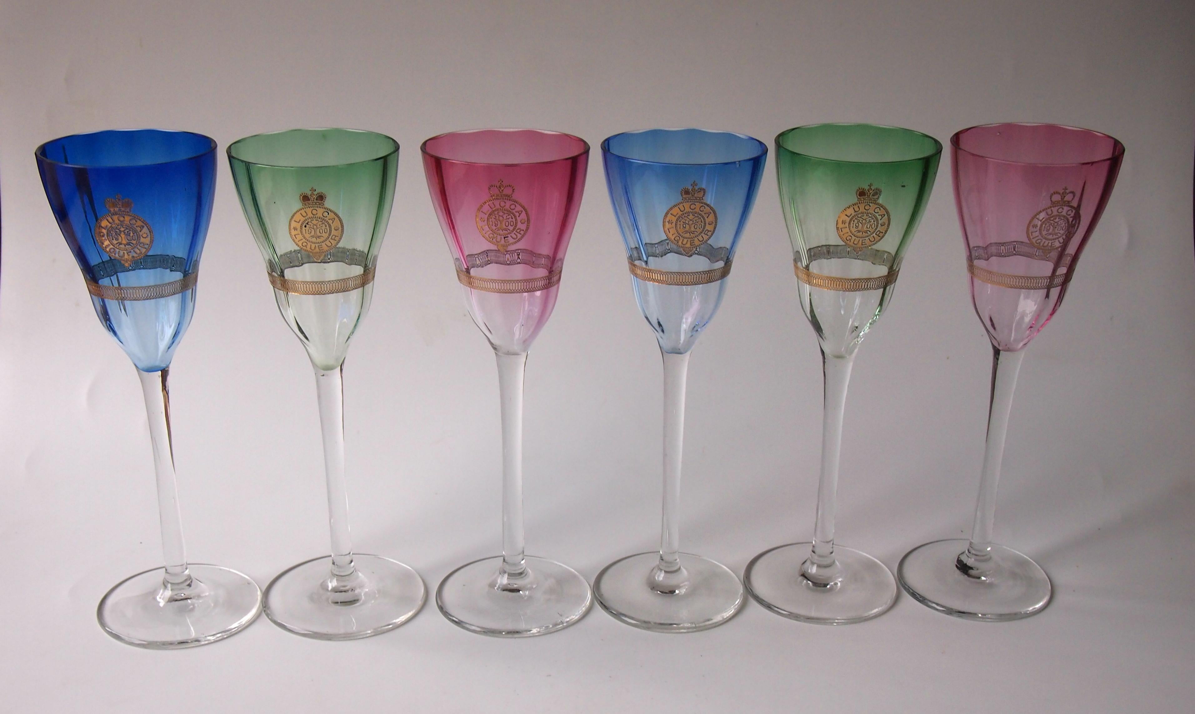 Superb full set of six Art Nouveau 'Lucca Liquor' glasses designed by Koloman Moser and made by Meyr's Neffe; a pair each in green, pink and blue - each are marked with a circular shield saying Lucca Liquors and the date 1900. The pink glass shields