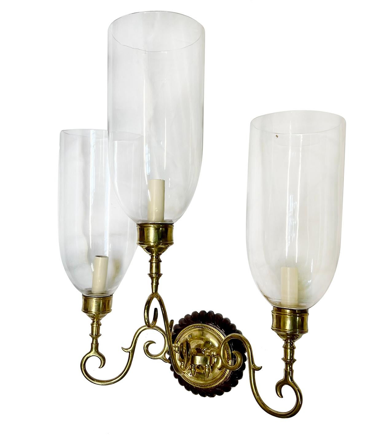 Set of four large circa 1950's three-arm Anglo-Indian sconces with wooden backplate and brass finish. Sold in pairs.

Measurements:
Height: 23
