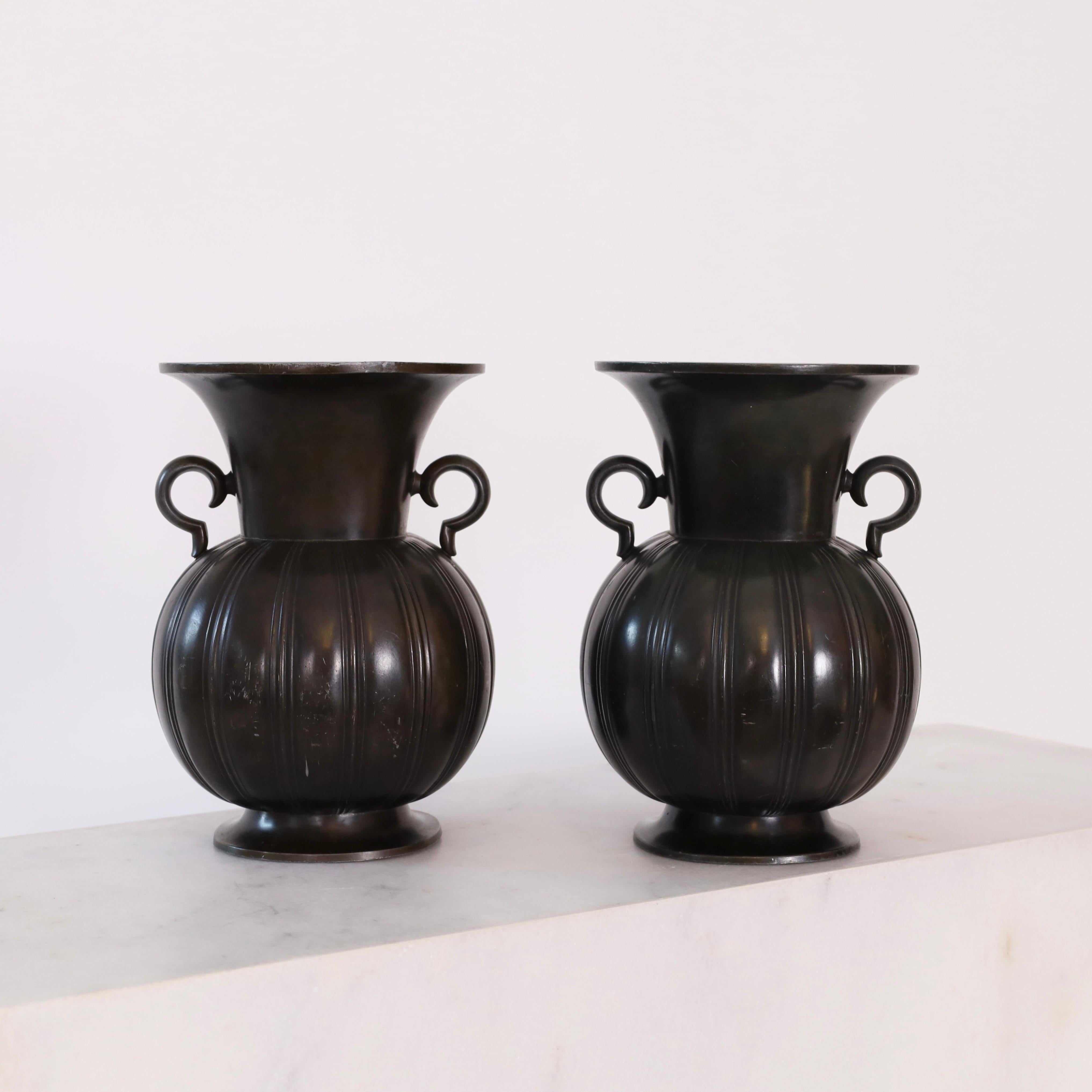 Set of large amphora-style metal vases designed by Just Andersen in the 1930s. An impressive duo for a beautiful place. 

* A set (2) amphora-style of metal vases with lugs 
* Designer: Just Andersen
* Model: D1925
* Year: 1937
* Condition: Good