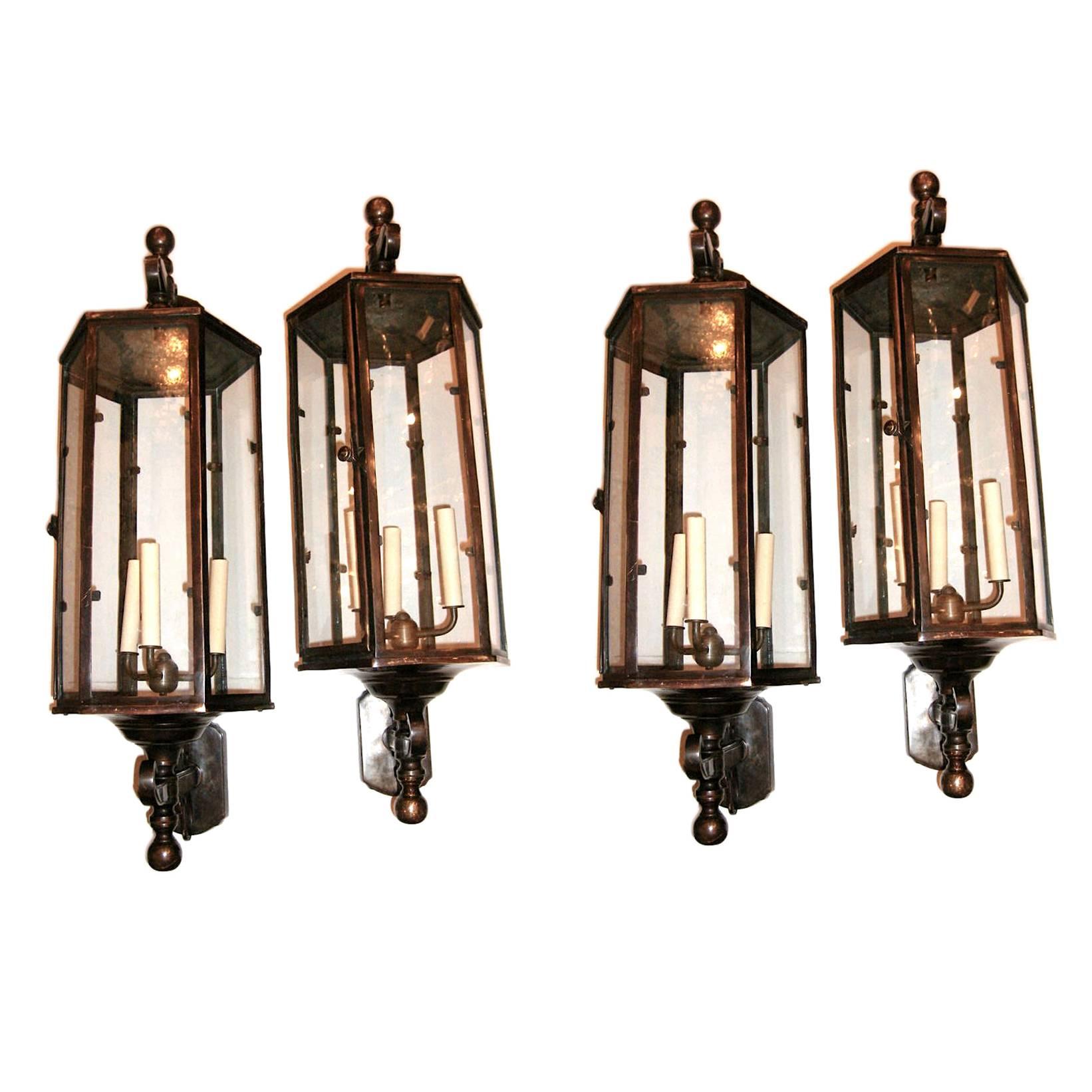 Pair of four large English circa 1920s patinated bronze wall-mounted indoor or outdoor wall lanterns with four interior lights and clear glass panels. Sold in pairs.

Measurements:
Height 34