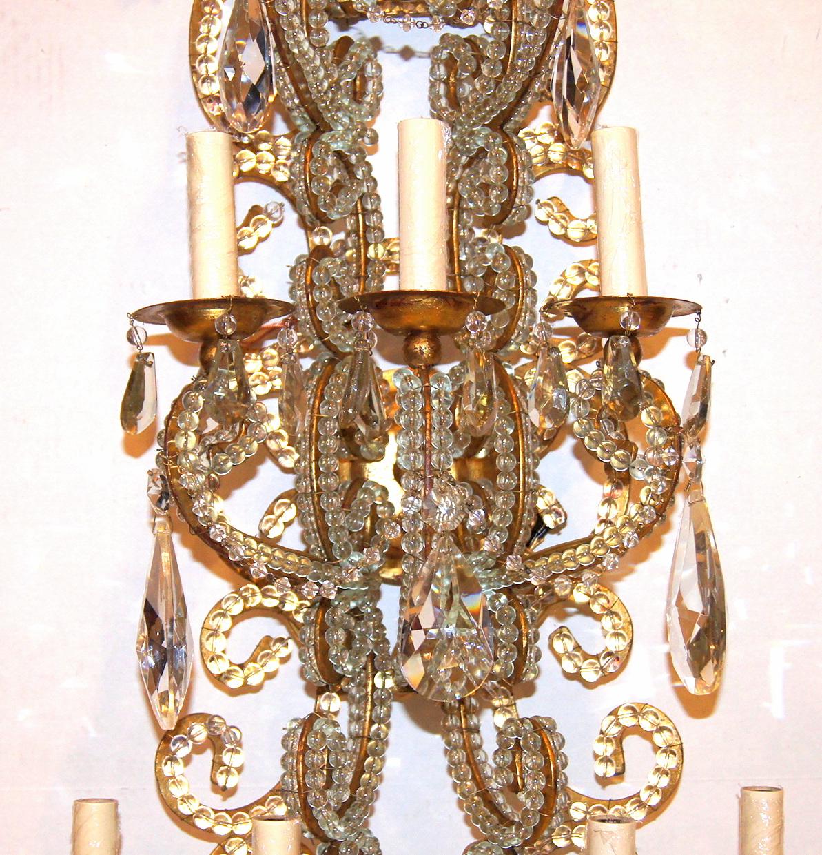 Satz von vier großen italienischen neunarmigen Wandleuchtern aus vergoldetem Metall und Kristall aus den 1940er Jahren mit Originalpatina. Verkauft in Paaren.

Abmessungen:
Höhe: 41,5