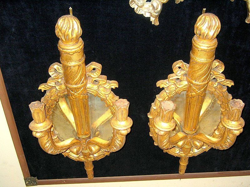 Set di quattro grandi appliques a doppia luce in legno intagliato e dorato degli anni '30 circa, con schienale a specchio. Venduto al paio.

Misure:
Altezza 30