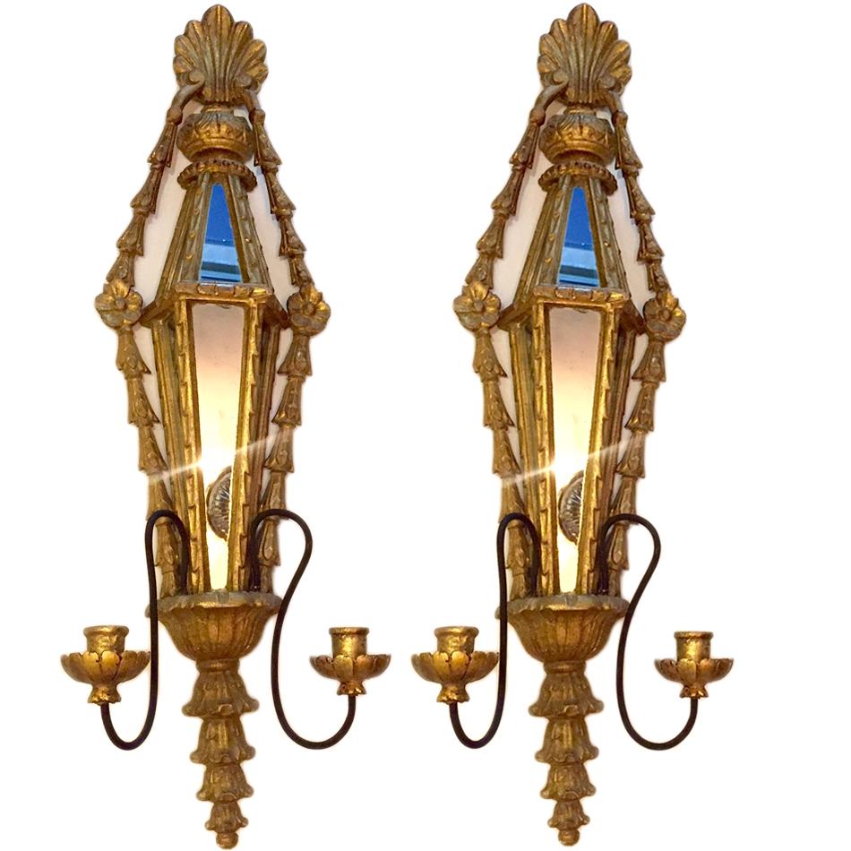 A set of four large circa 1930s French, double light carved wood sconces with original gold leaf finish and mirror insets on backplates. Sold per pair.

Measurements:
Height: 34
