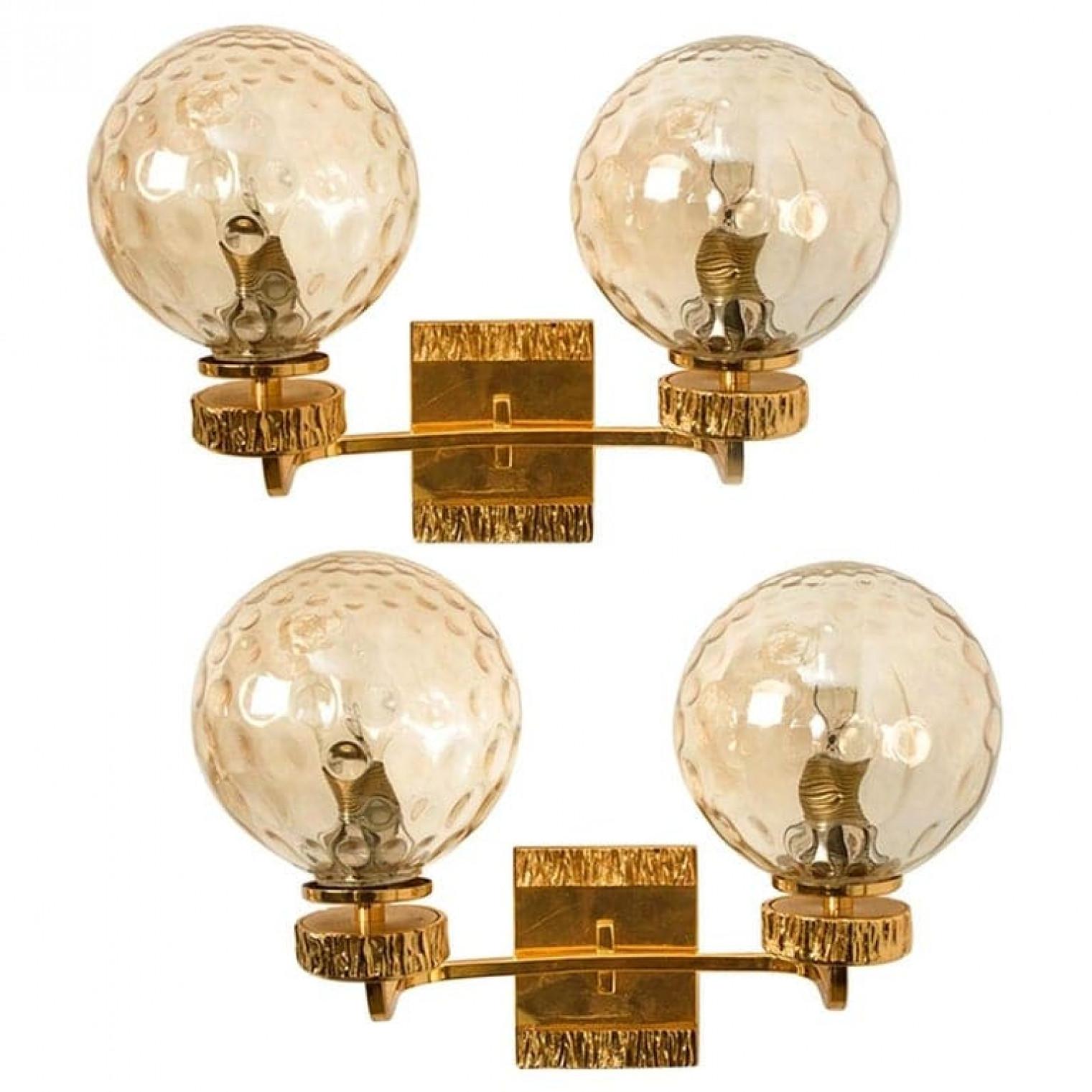 Questo splendido set di lampade da parete, con una boccia di vetro e accessori placcati in oro, è stato prodotto negli anni '70 nello stile di Brotto. Illumina meravigliosamente. Elegante e raffinato, si adatta a tutti i periodi di