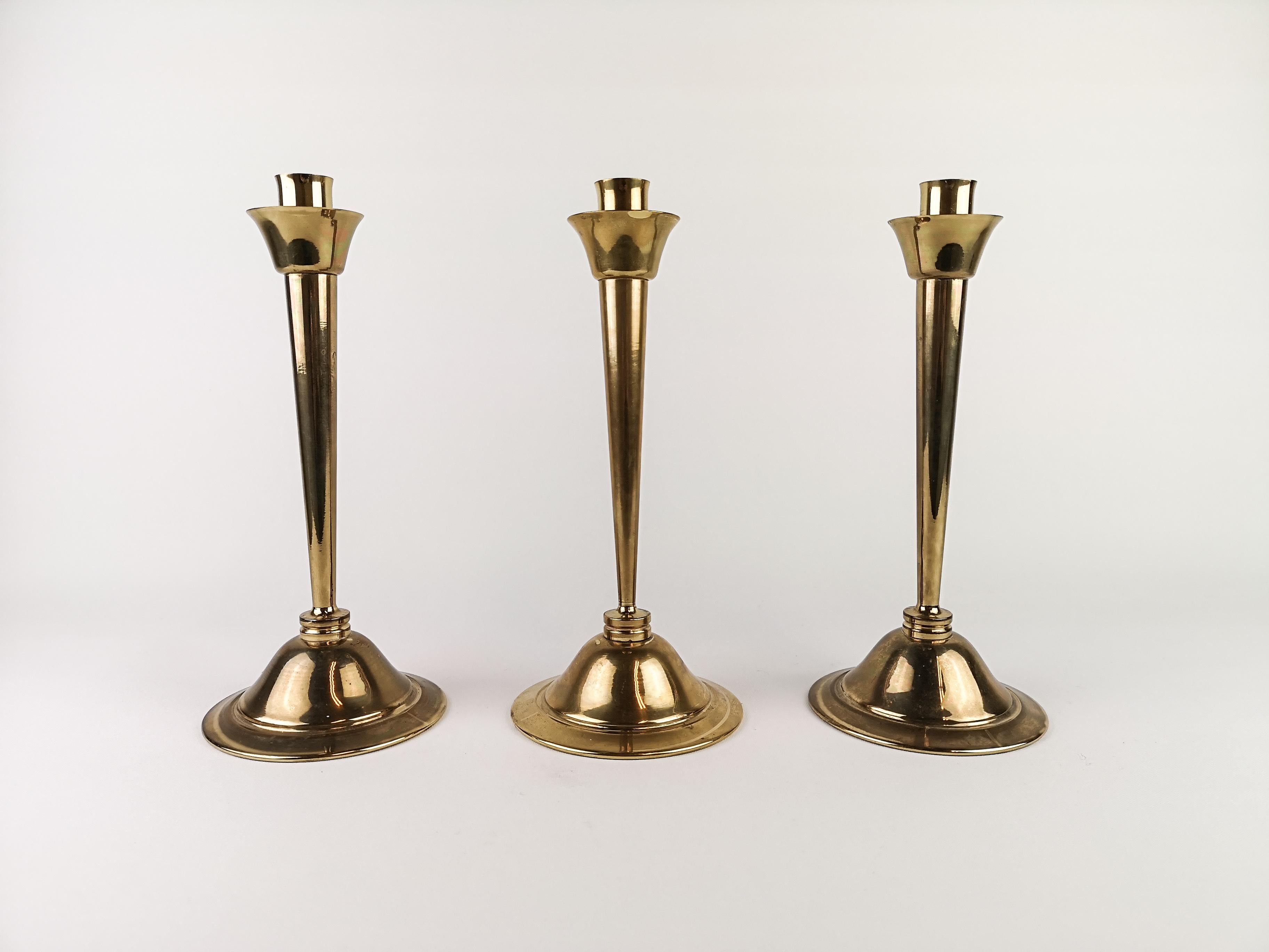 Set of 3 brass candlesticks designed by Lars Holmström. Produced by Lars Holmström in Arvika, Sweden. All of them are signed. 

Signs of ware and use.