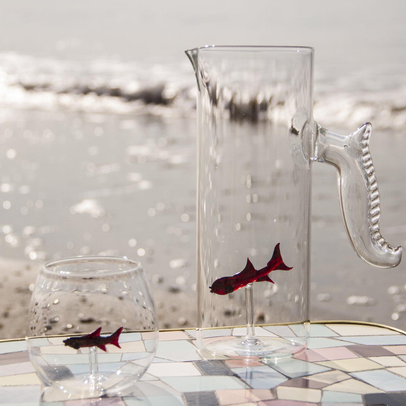 This little fish set will add a colorful and whimsical touch to any dining table. The tall transparent pitcher features a nautical handle and shares with the glasses the addition of an exquisitely rendered glass fish that seems to float thanks to a