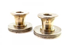Set of low silver candlesticks set on circular bases with relief friezes