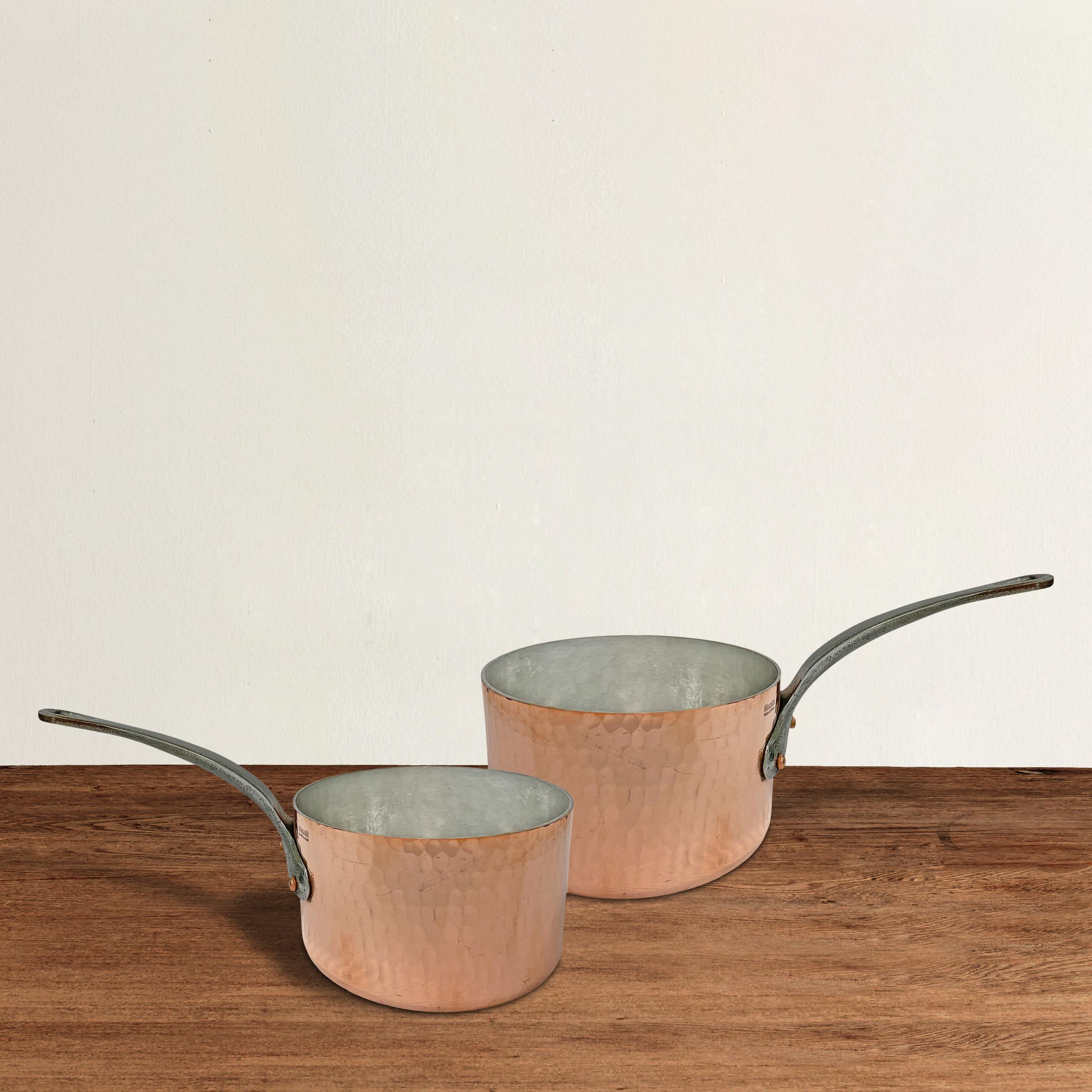 A striking set of early 21st century French hammered 3 mm copper saucepans by Mauviel, each with iron handles, a sign that these were intended for commercial restaurant use. The pans have been newly tinned and are ready for use.

Small: 12.75 in.