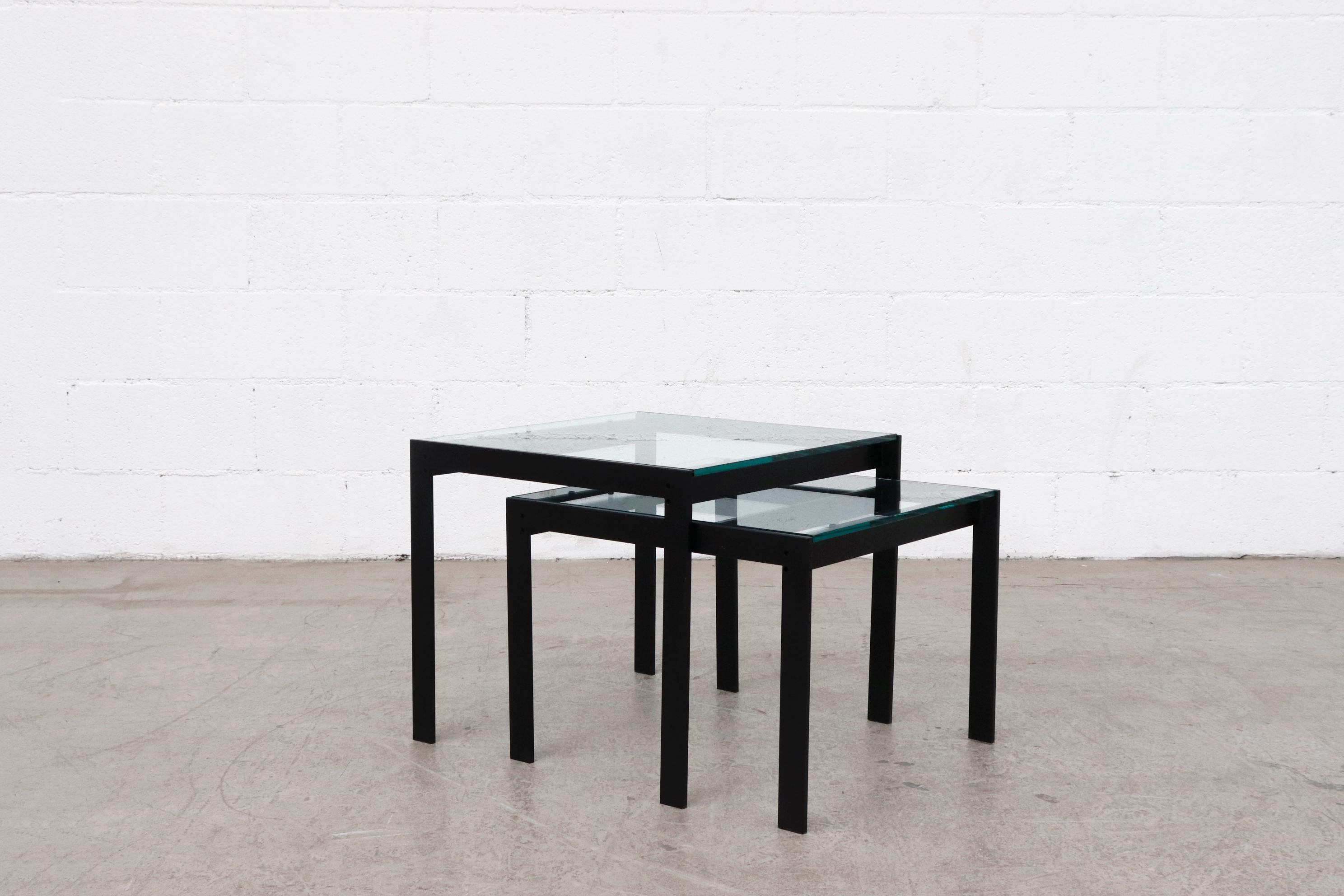 Amazing pair of Metaform attributed nesting tables with black powder coated aluminum frames and thick new square glass tops. Smaller table measures 19.5 x 19.5 x 15.63. In overall impressive condition with some wear consistent with age and use.