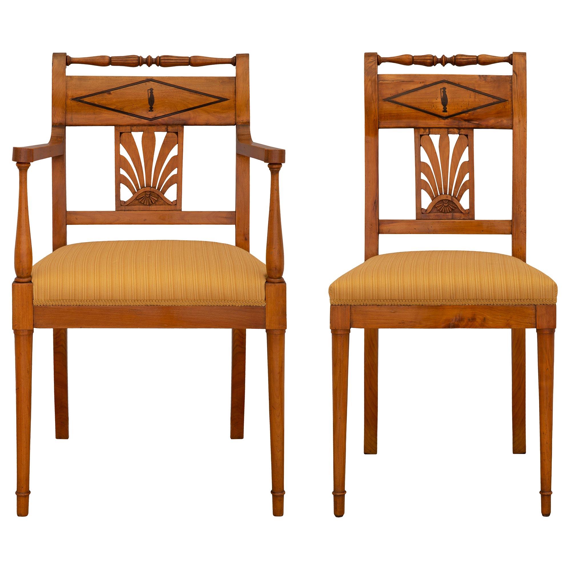 An elegant set of eight Continental 19th century Biedermeier st. Cherrywood and ebonized Fruitwood dining chairs. The set consists of two arm chairs and six side chairs each raised by two beautiful circular tapered legs with fine topie shaped feet