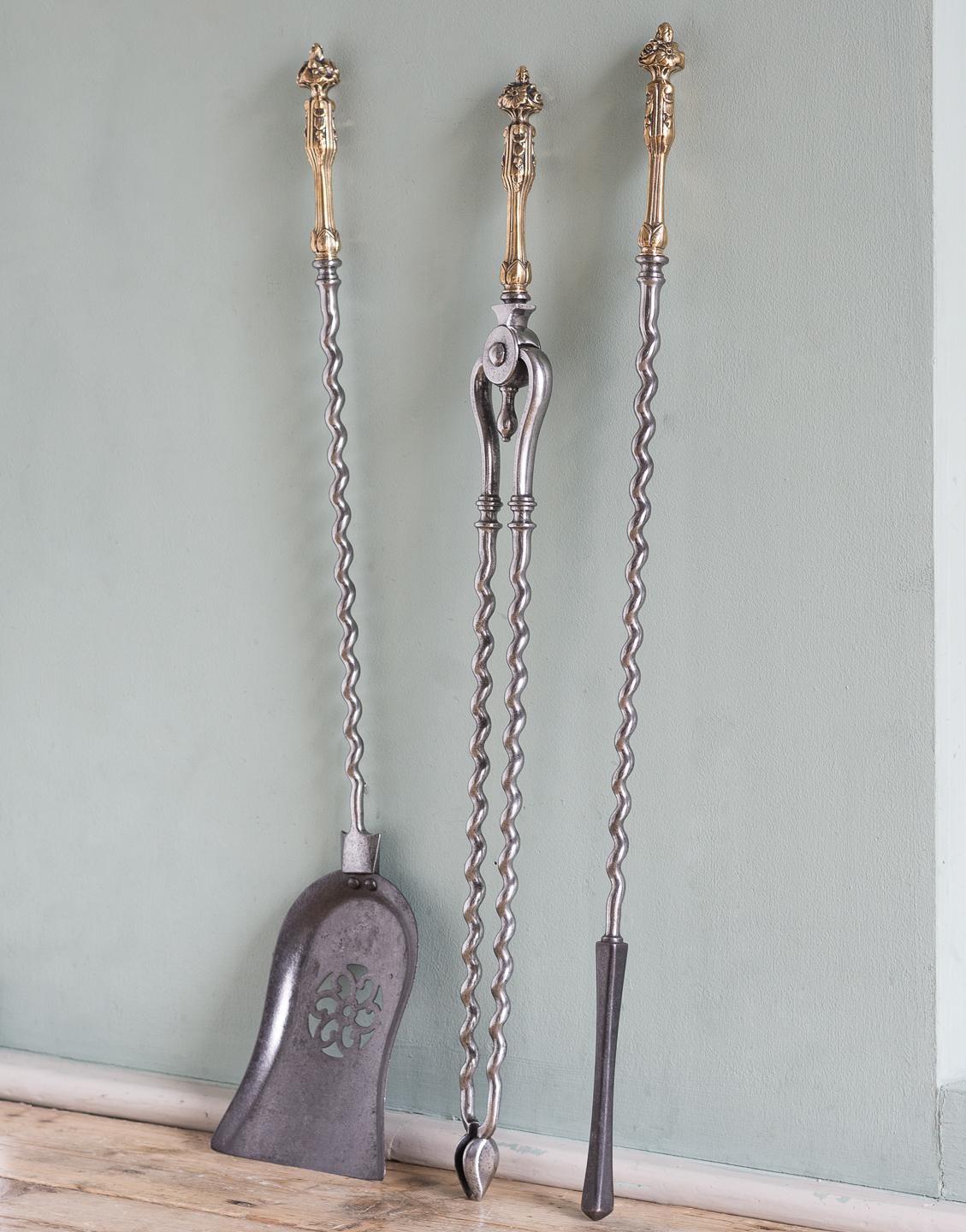 A set of mid-19th century brass and steel fire irons, comprising tongs, shovel and poker, with wrythen stems.