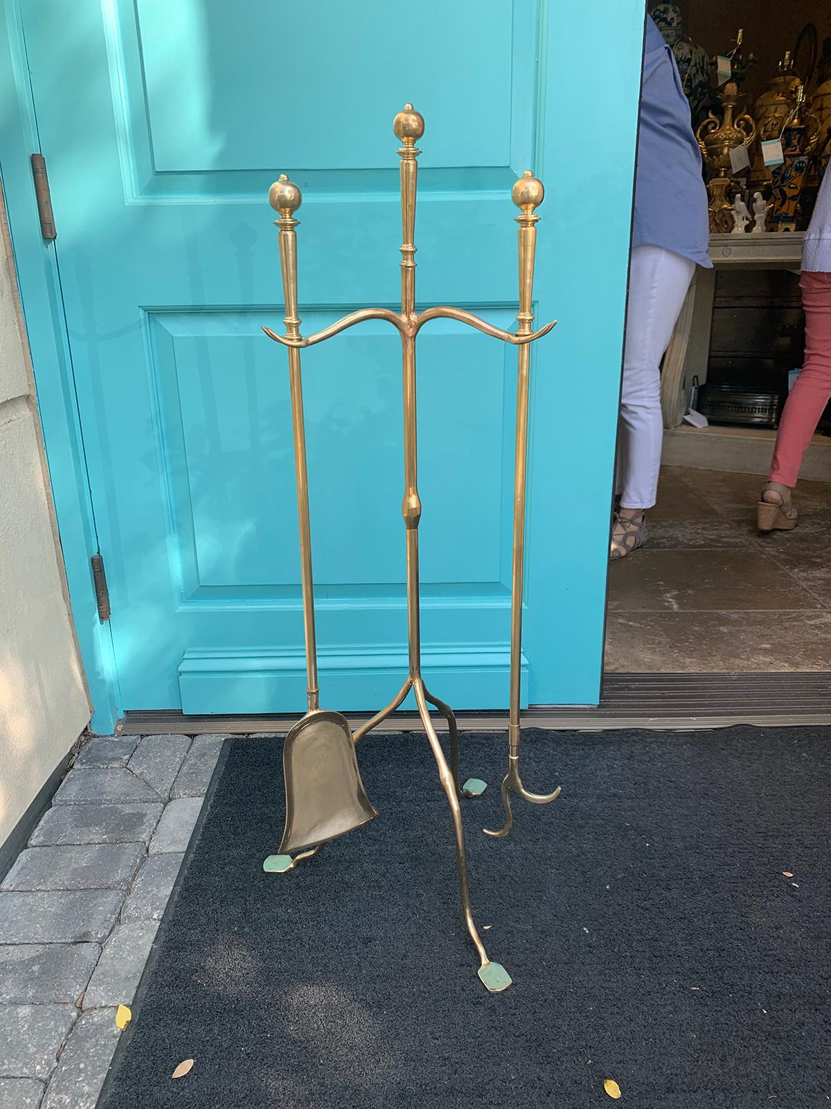 Set of mid-20th century brass fire tools on stand, shovel and poker.