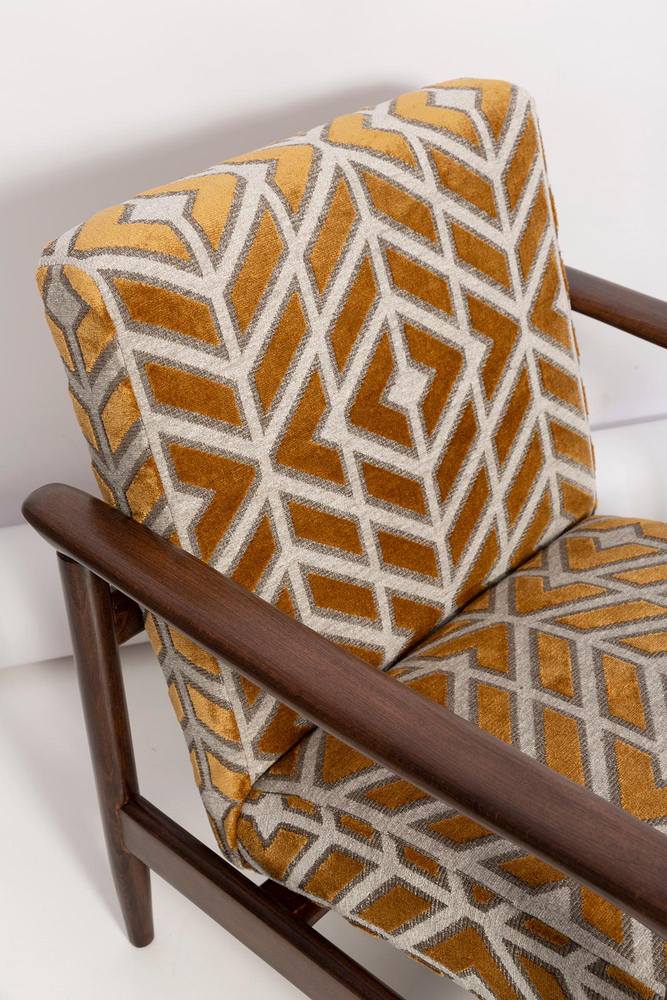 A pair of mid century armchairGFM-142 and stool, designed by Edmund Homa. The furnitures were made in the 1960s in the Gosciecinska Furniture Factory. They are made from solid beech wood. The GFM-142 armchair is regarded one of the best Polish