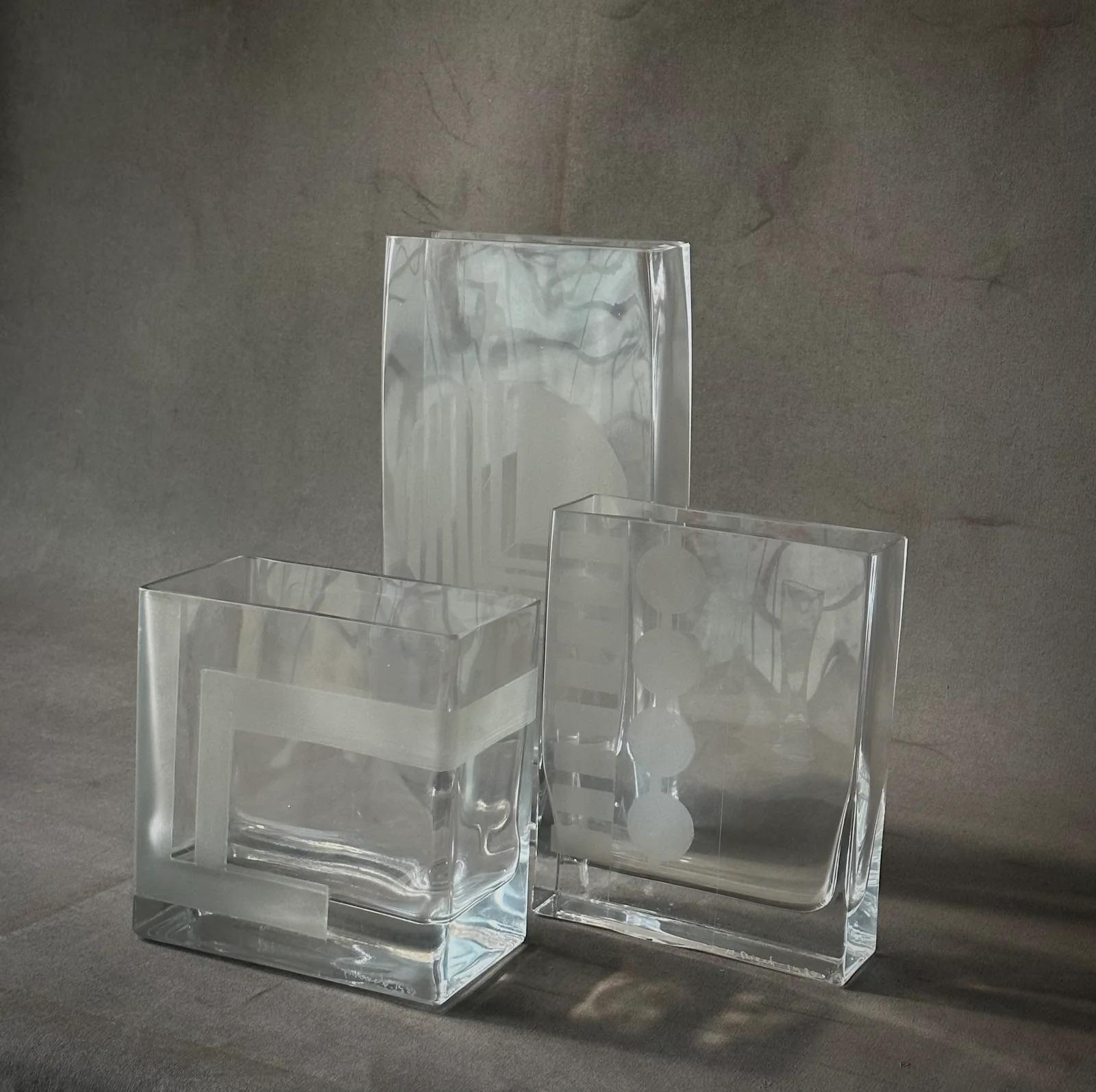Questo affascinante set di tre vasi in vetro francese della metà del secolo scorso emana un'estetica elegante e moderna; ogni pezzo è realizzato con un design unico smerigliato e acidato. Le forme rettangolari, in dimensioni graduate, si armonizzano